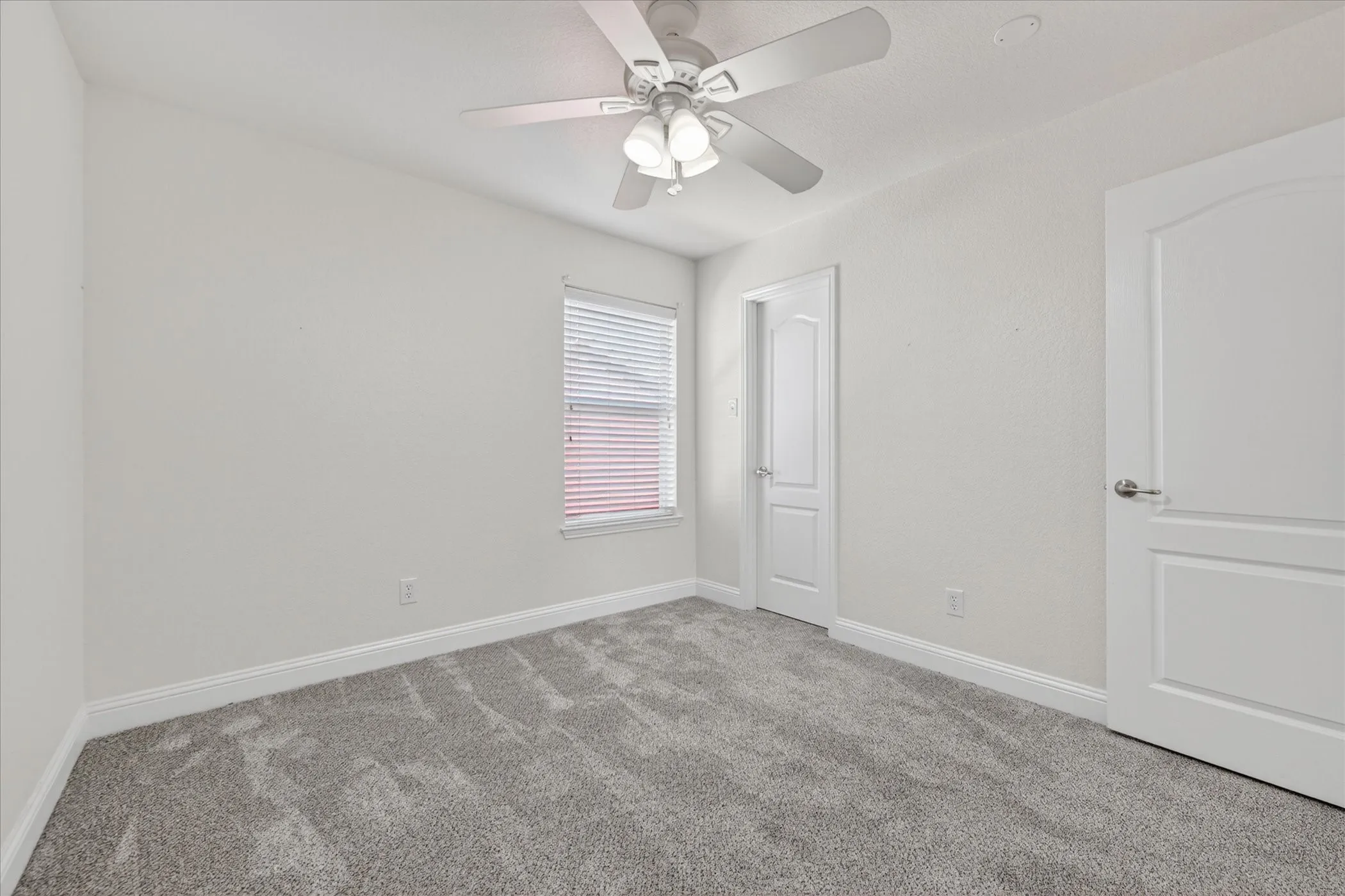 Bedroom Four Neutral wall tones with gray carpeting