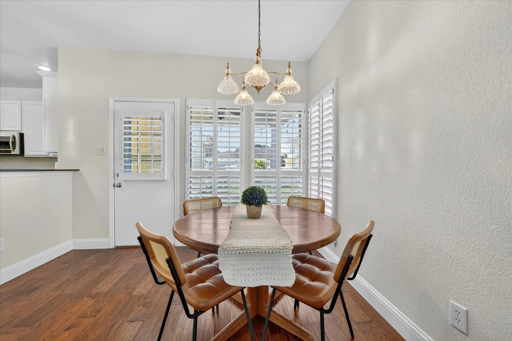 Dining area featuring warm wood-finish flooring and a decorative chandelier
