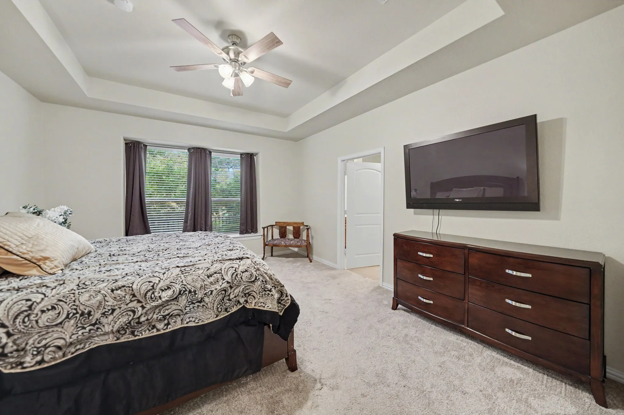 Primary bedroom overlooks the private backyard and treed greenbelt