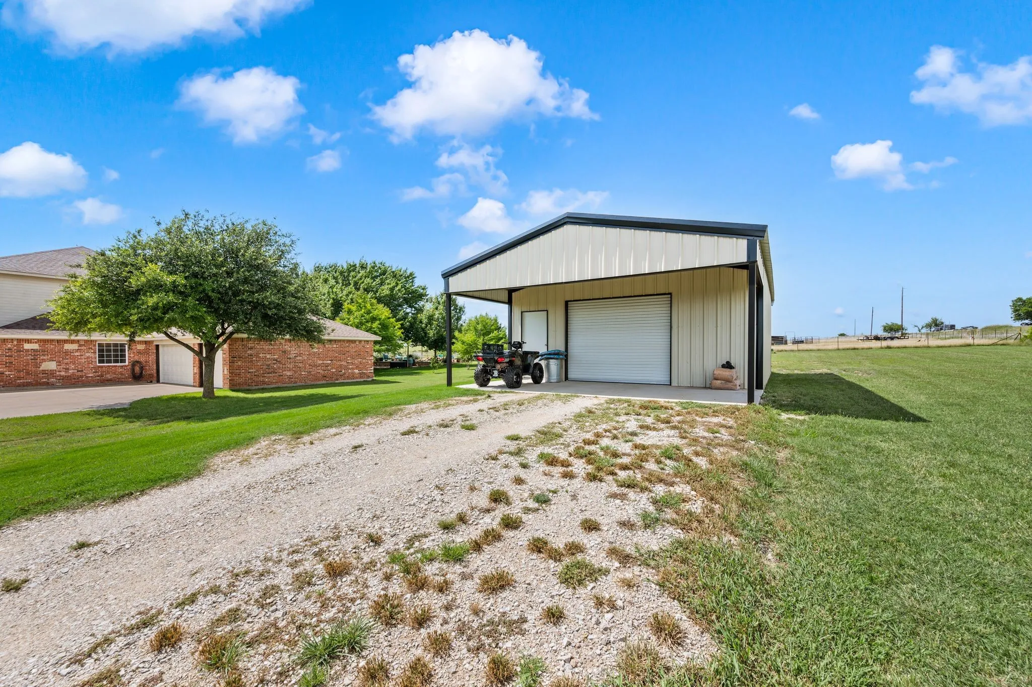 Metal-frame outbuilding with an overhead door and covered parking