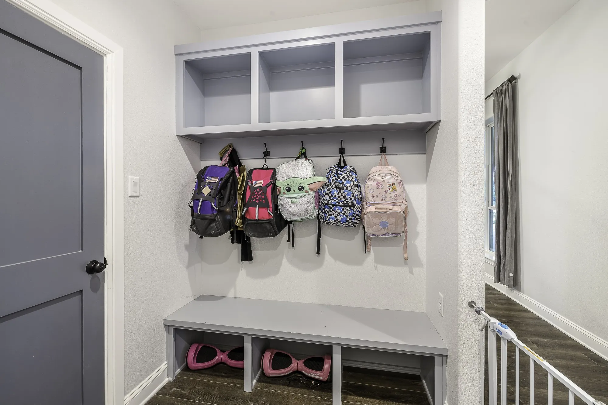 Built-in entryway storage featuring a bench, individual cubbies, and overhead shelving