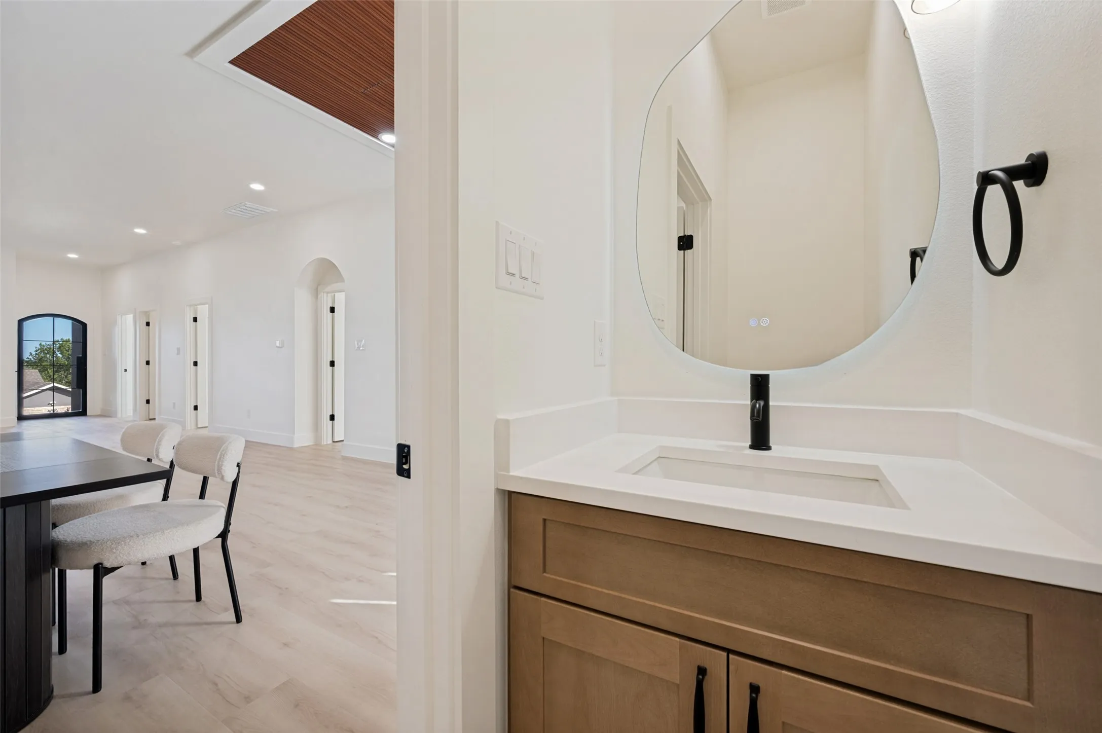 Powder room featuring a single vanity with a light countertop, integrated rectangular sink, and matte black faucet