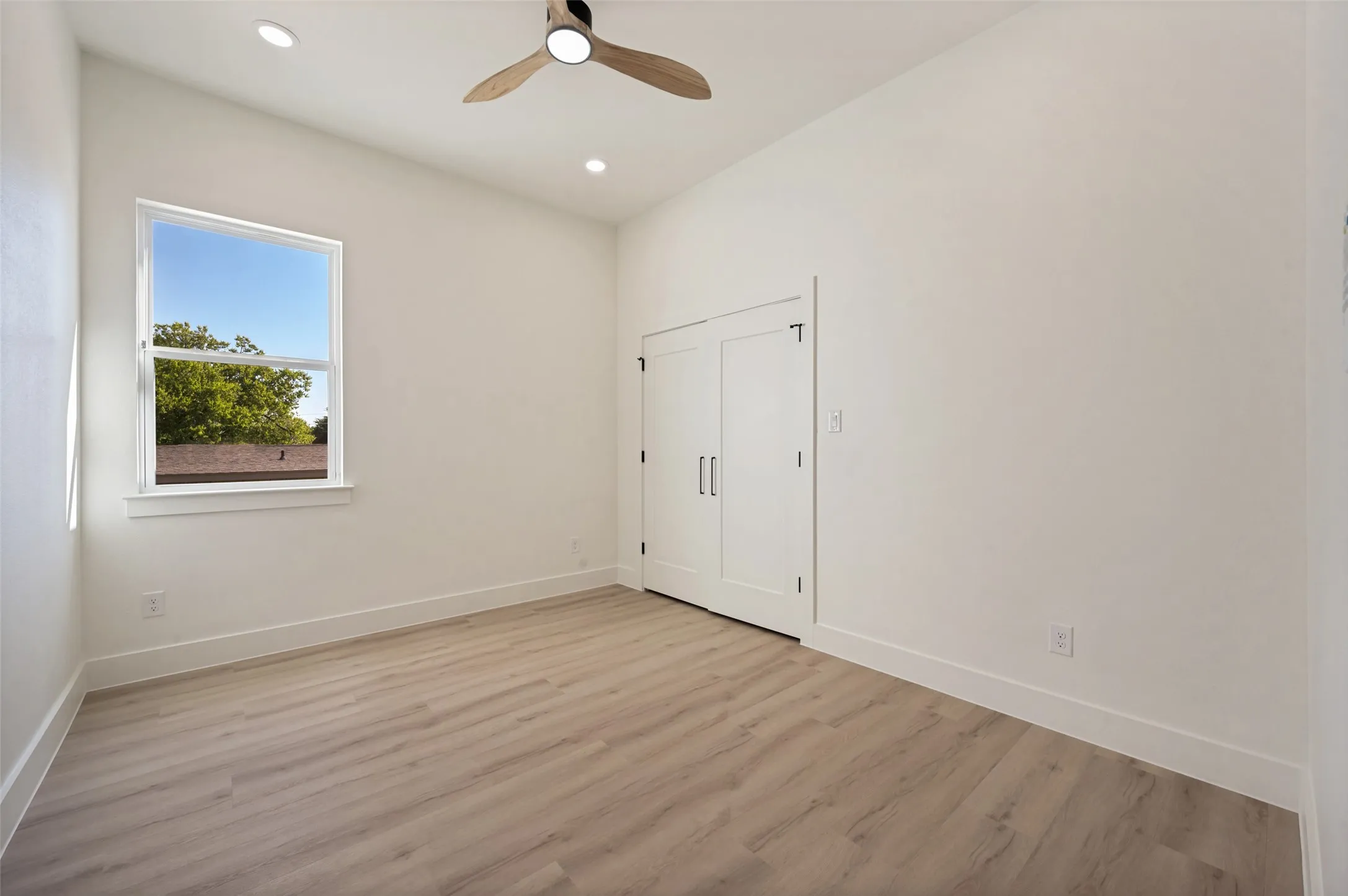 Room featuring wood-finish flooring, vaulted ceiling, and recessed lighting