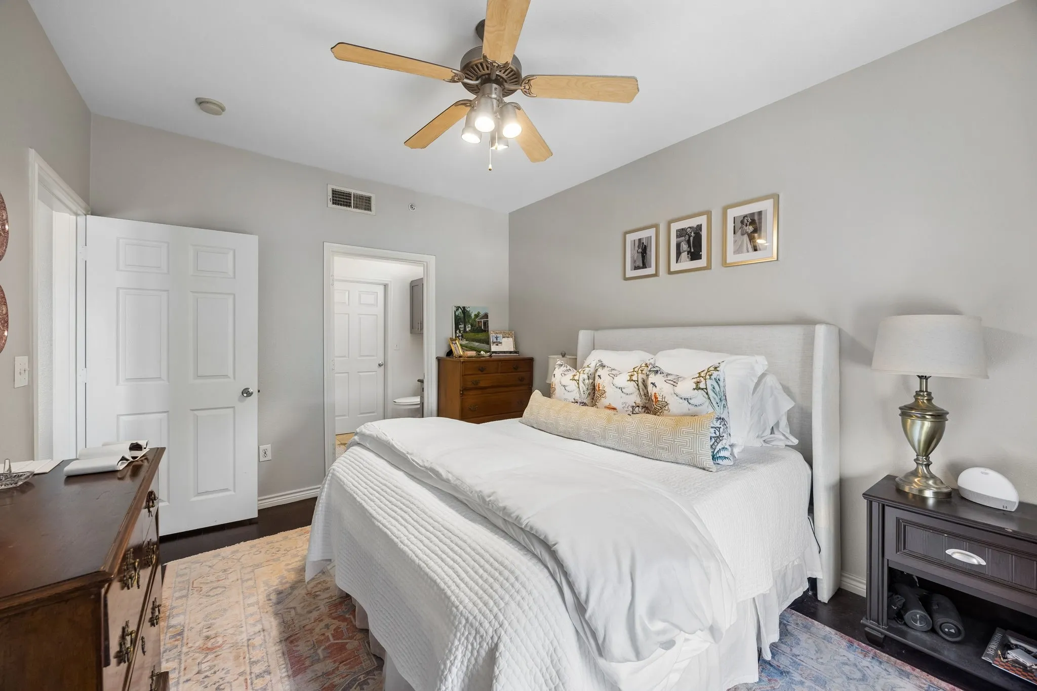 Bedroom featuring dark wood-finish flooring, light gray wall paint, and a ceiling fan with integrated lighting