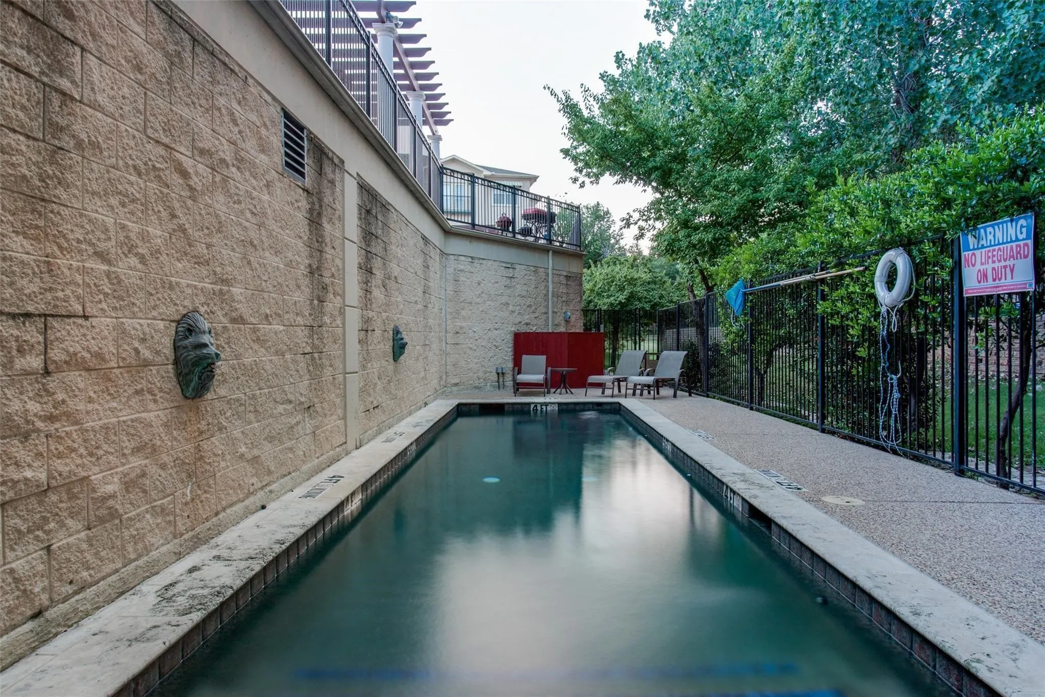 Rectangular swimming pool with stone coping and a textured aggregate deck