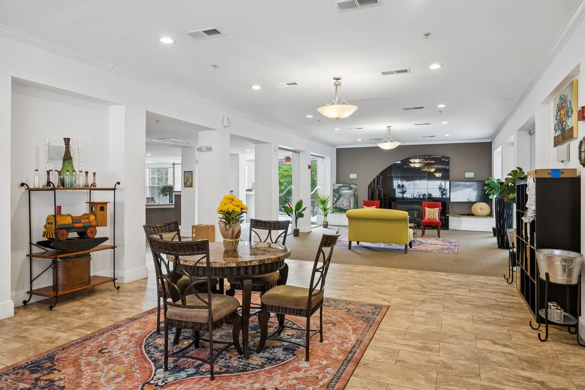 Spacious common area featuring light-toned tile flooring, recessed lighting, and multiple pendant light fixtures