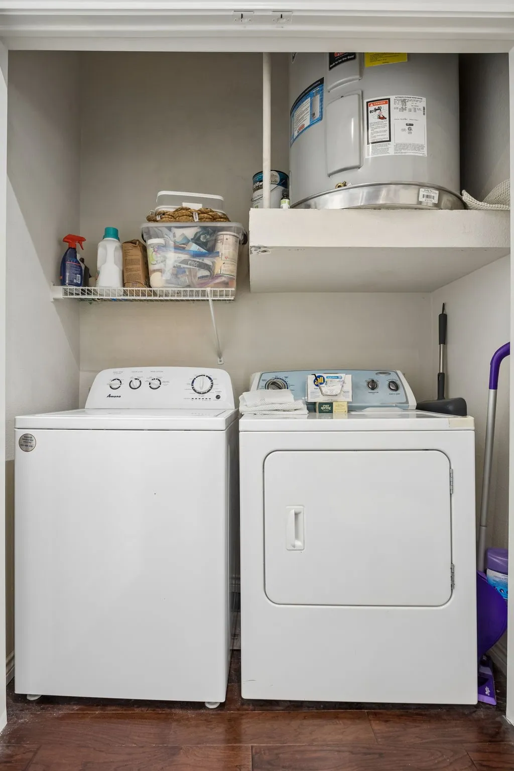 Dedicated laundry closet featuring a top-load washing machine, front-load dryer, and wood-finish flooring