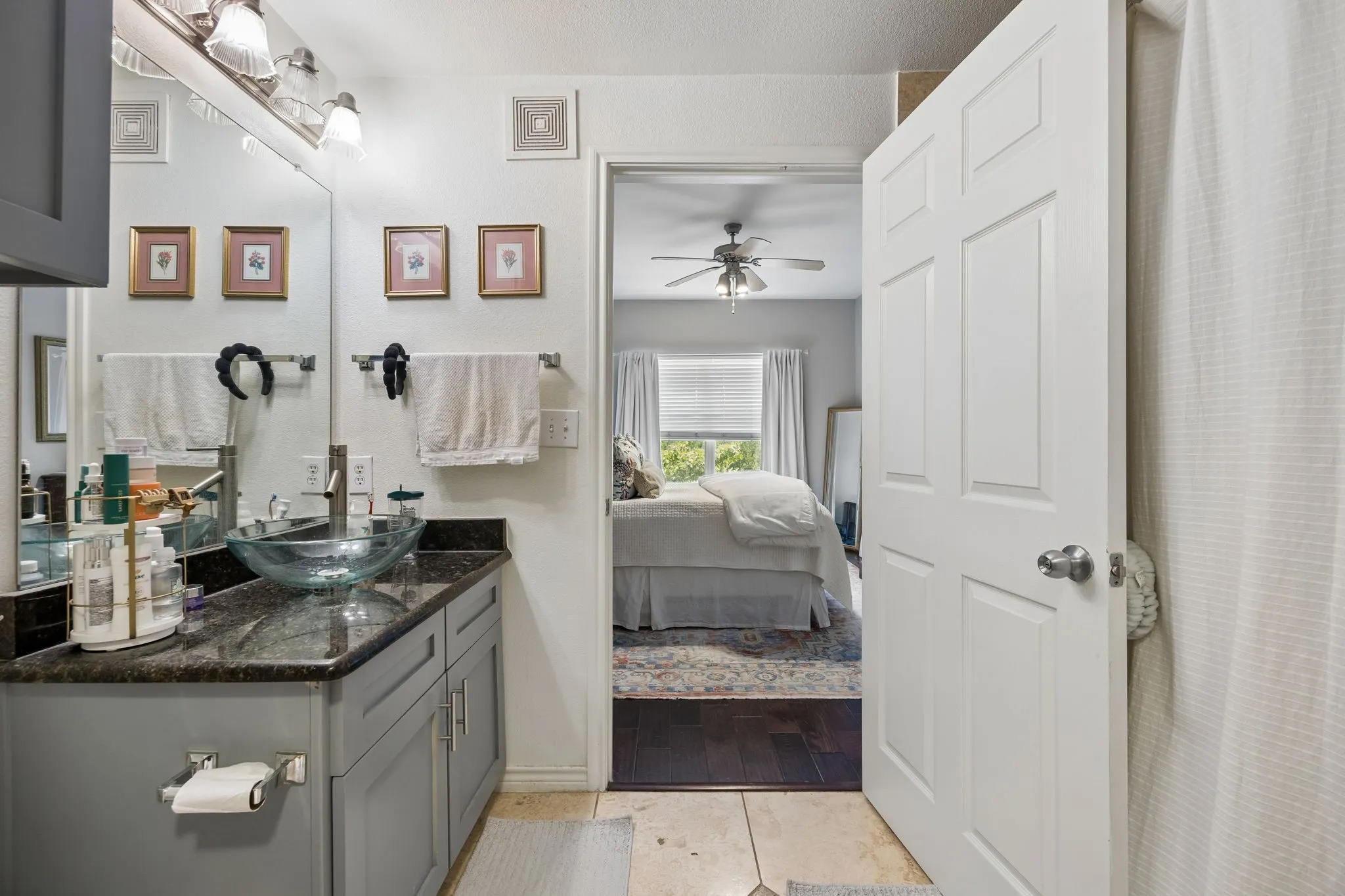 Bathroom featuring a gray vanity with a dark countertop and a glass vessel sink