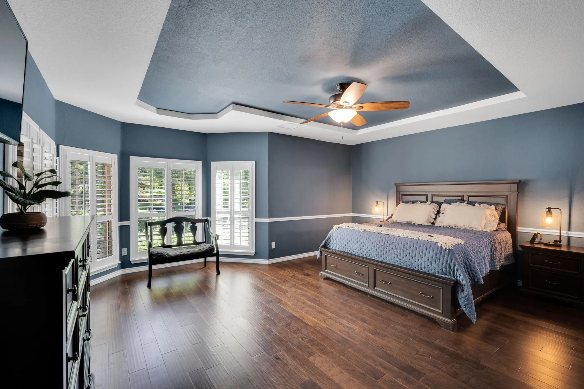 Spacious primary suite with a tray ceiling and private access to the backyard.