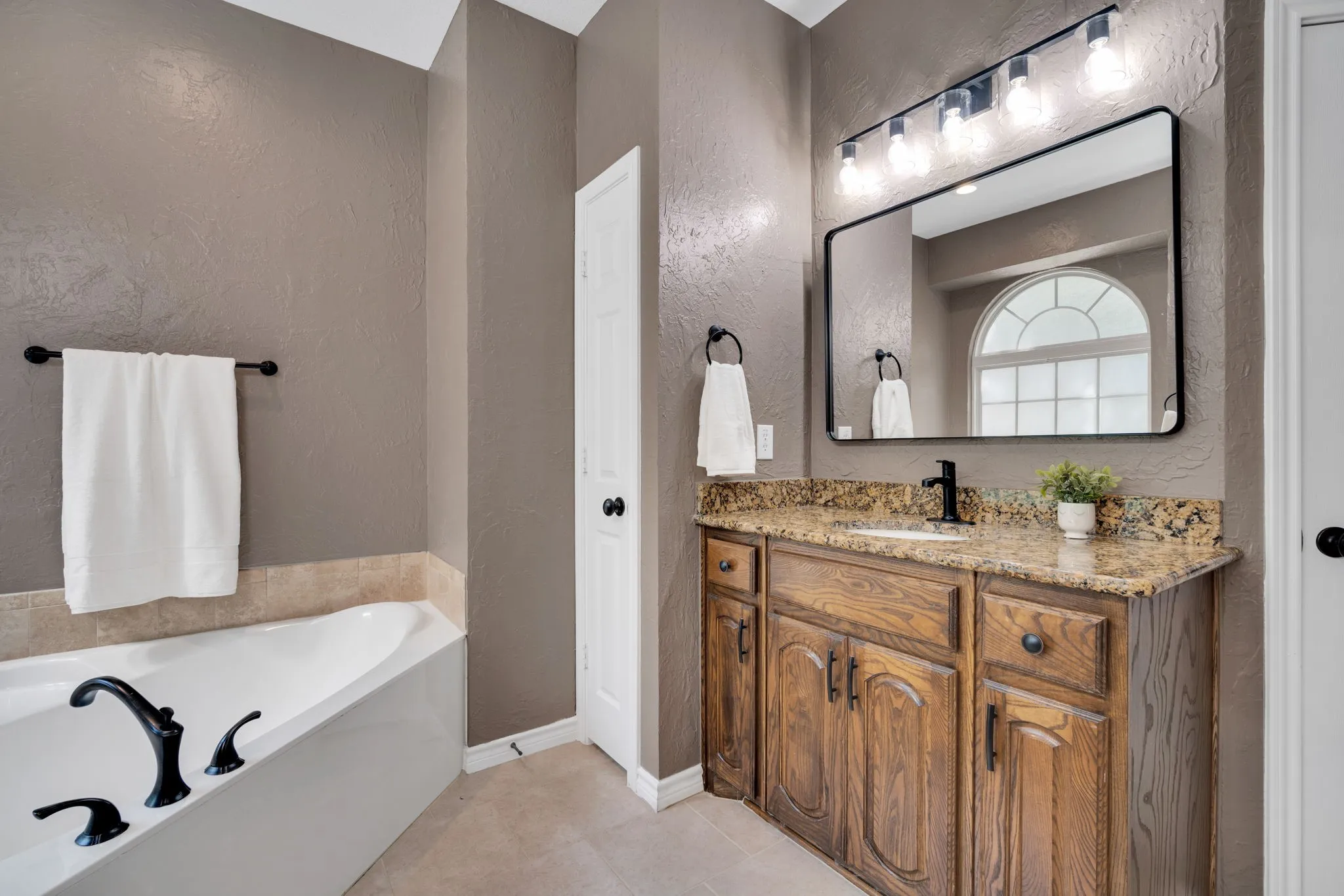 Primary bath featuring a relaxing soaking tub and a dedicated vanity area.