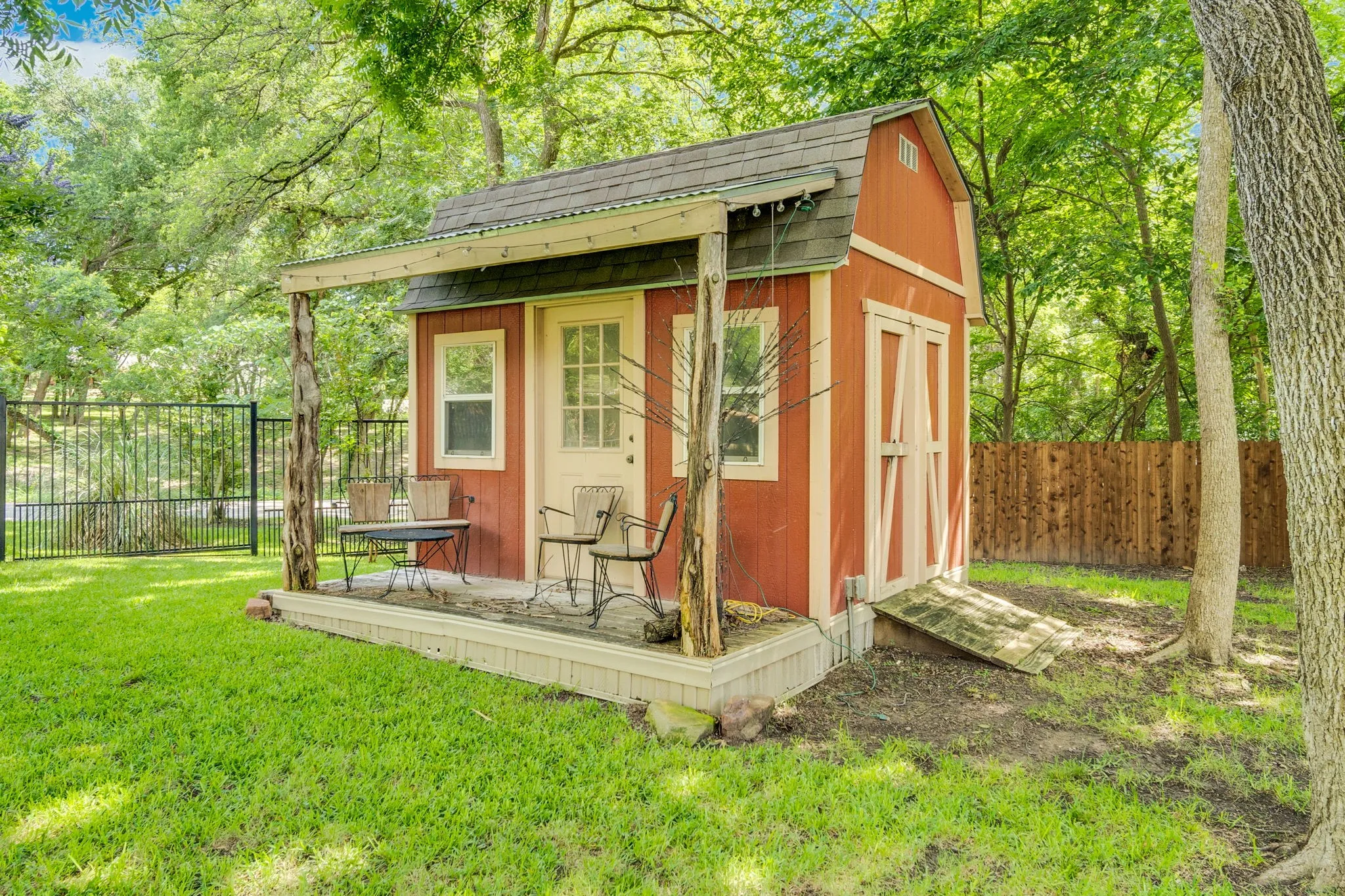 Charming outbuilding with a covered porch, tucked among the trees, perfect as a studio, workshop, or retreat.