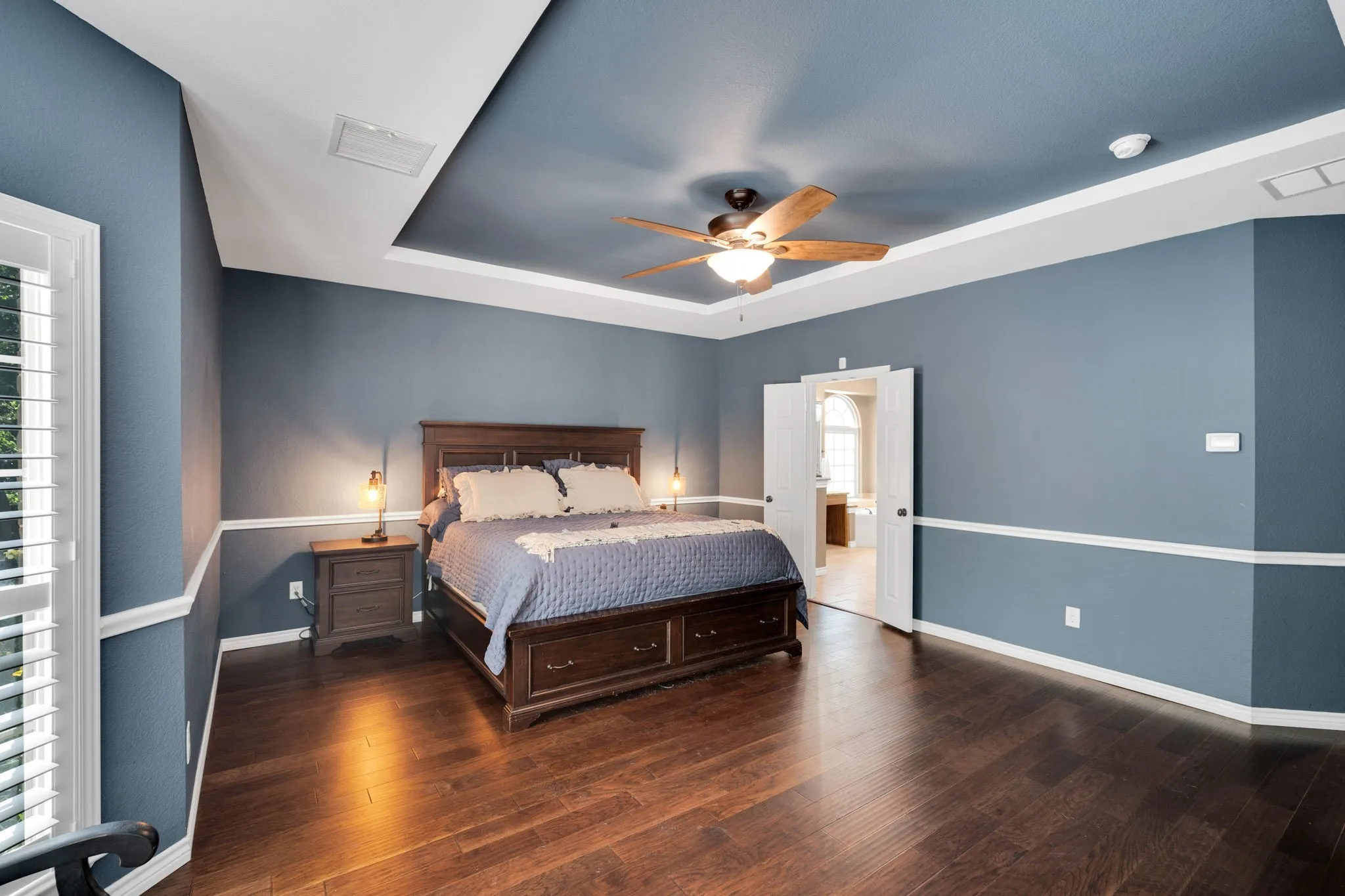 Primary bedroom retreat with a tray ceiling and direct access to the en-suite bath.