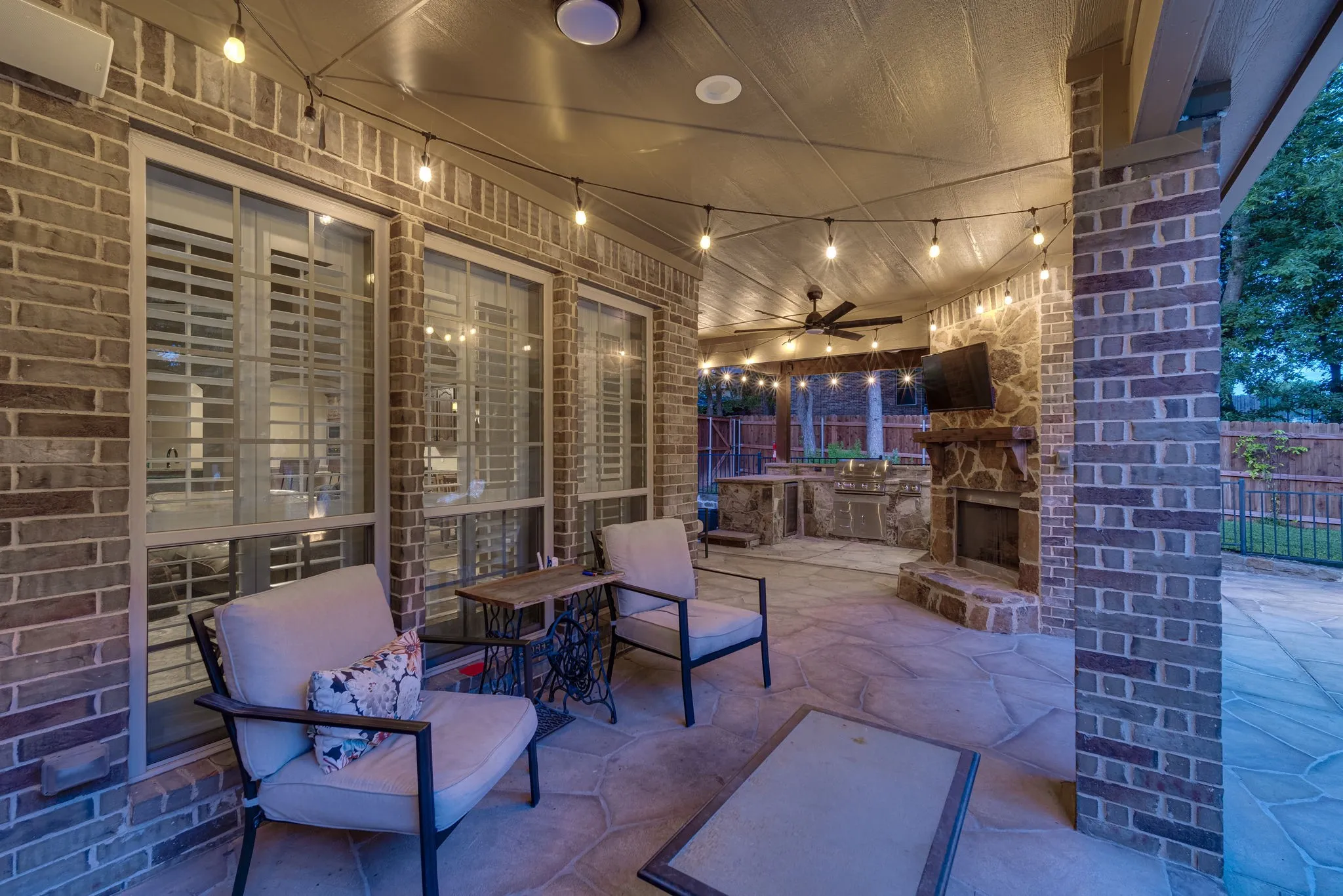 Covered patio with brick columns and stone flooring, an inviting spot for outdoor relaxation.