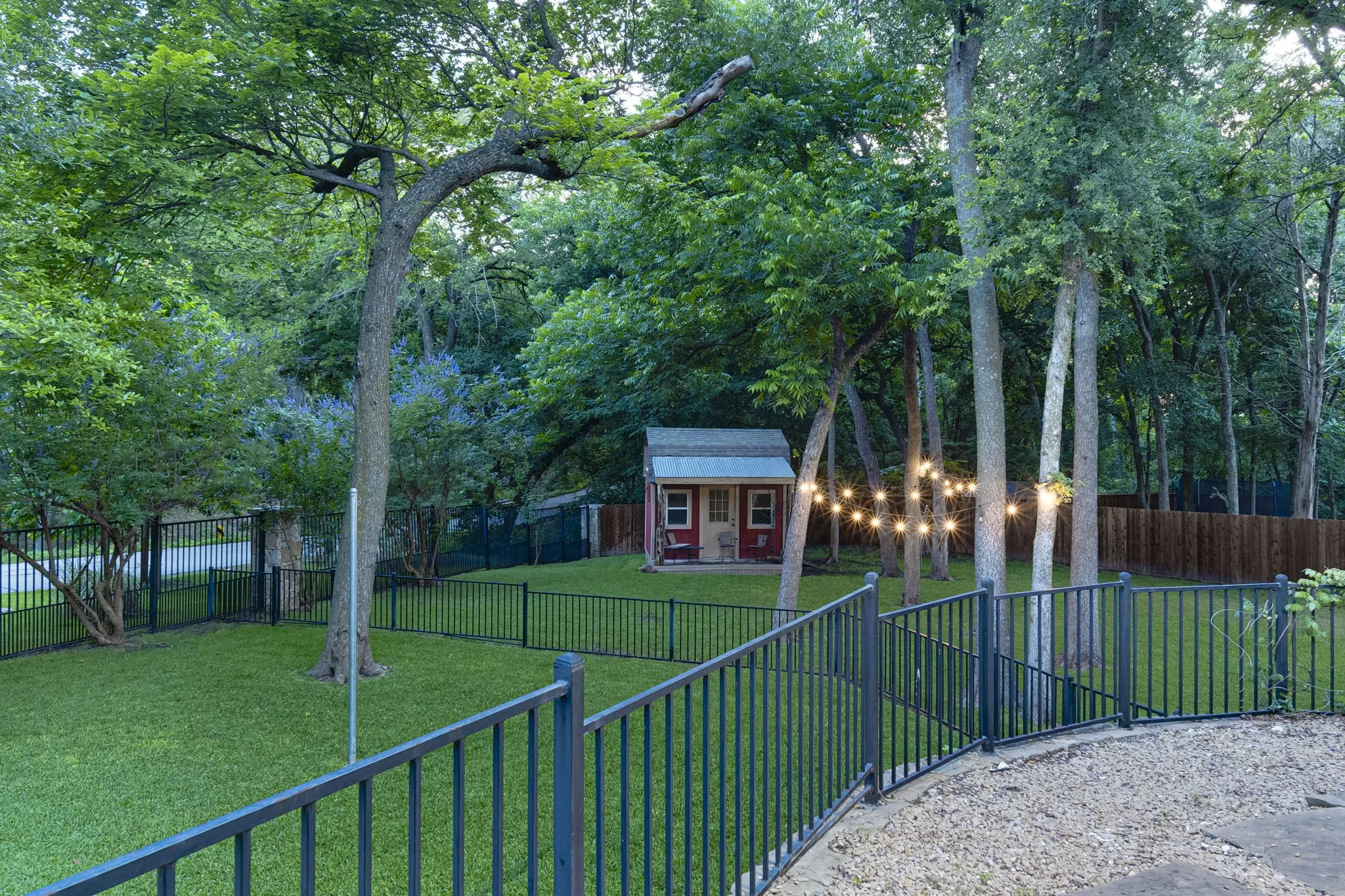 Wooded backyard retreat surrounding the outbuilding, offering privacy and shade.