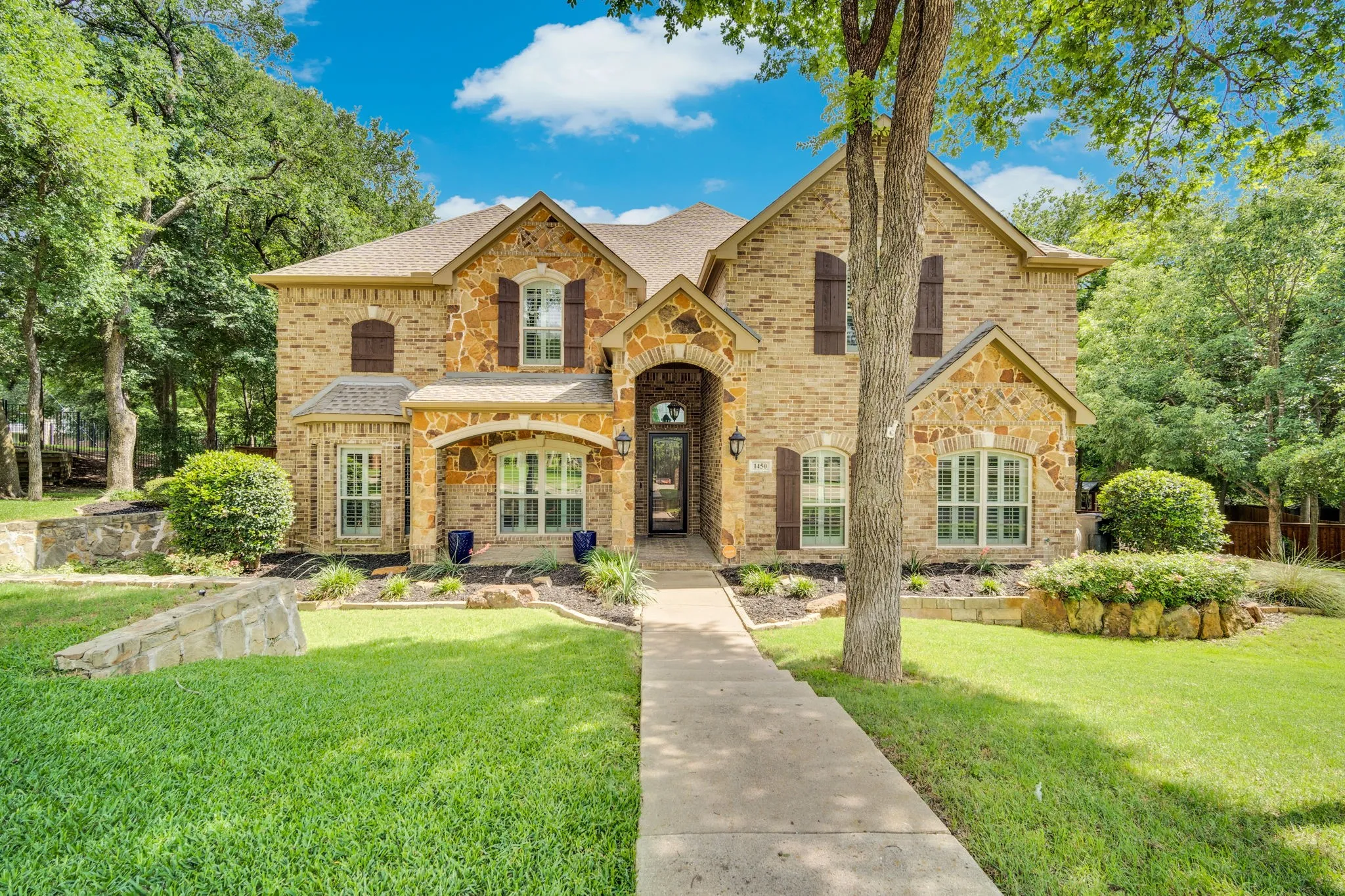 Front exterior showcasing the home's elegant stone and stucco architecture.