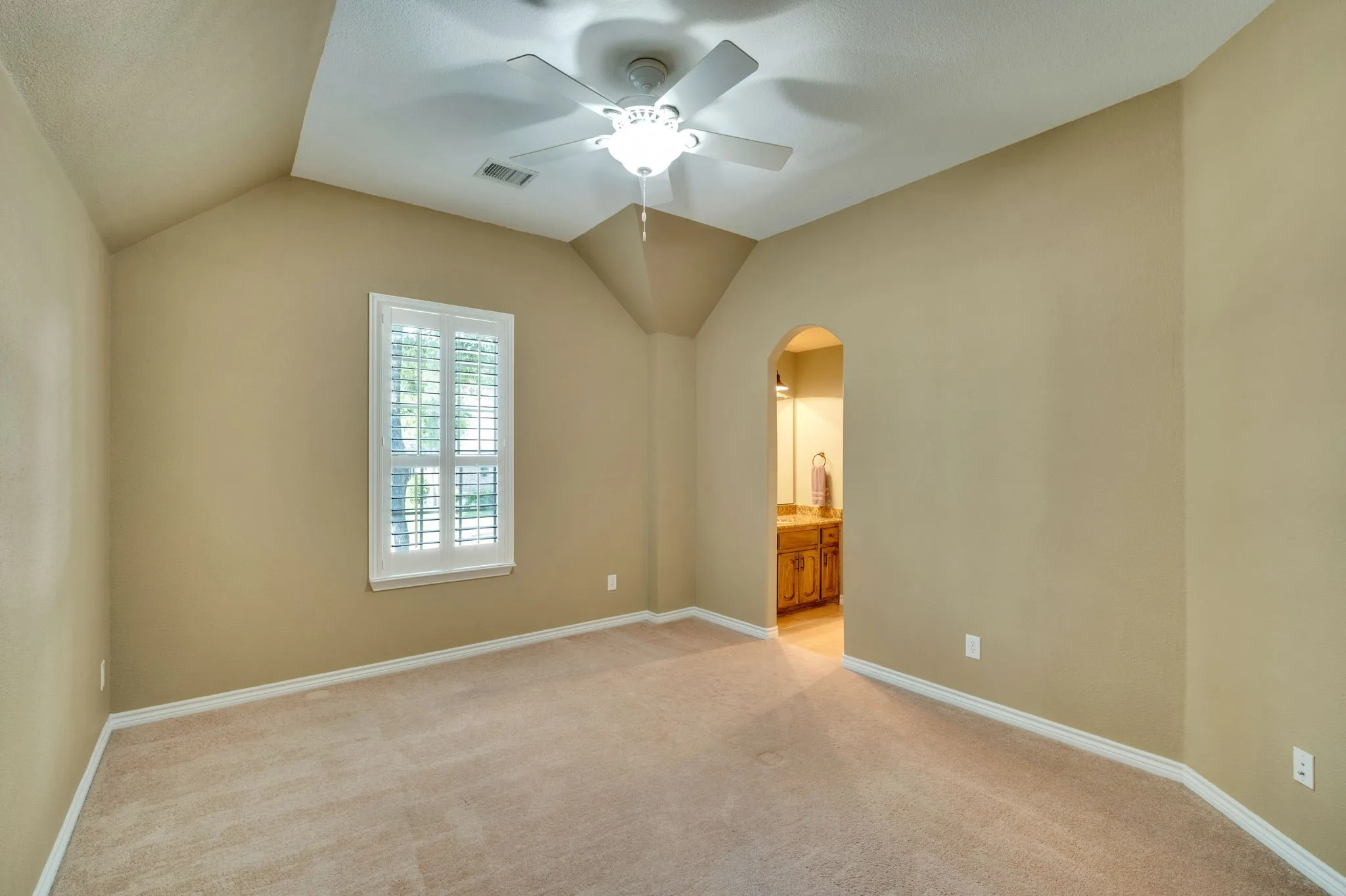 Secondary bedroom with a vaulted ceiling and en suite bathroom access.