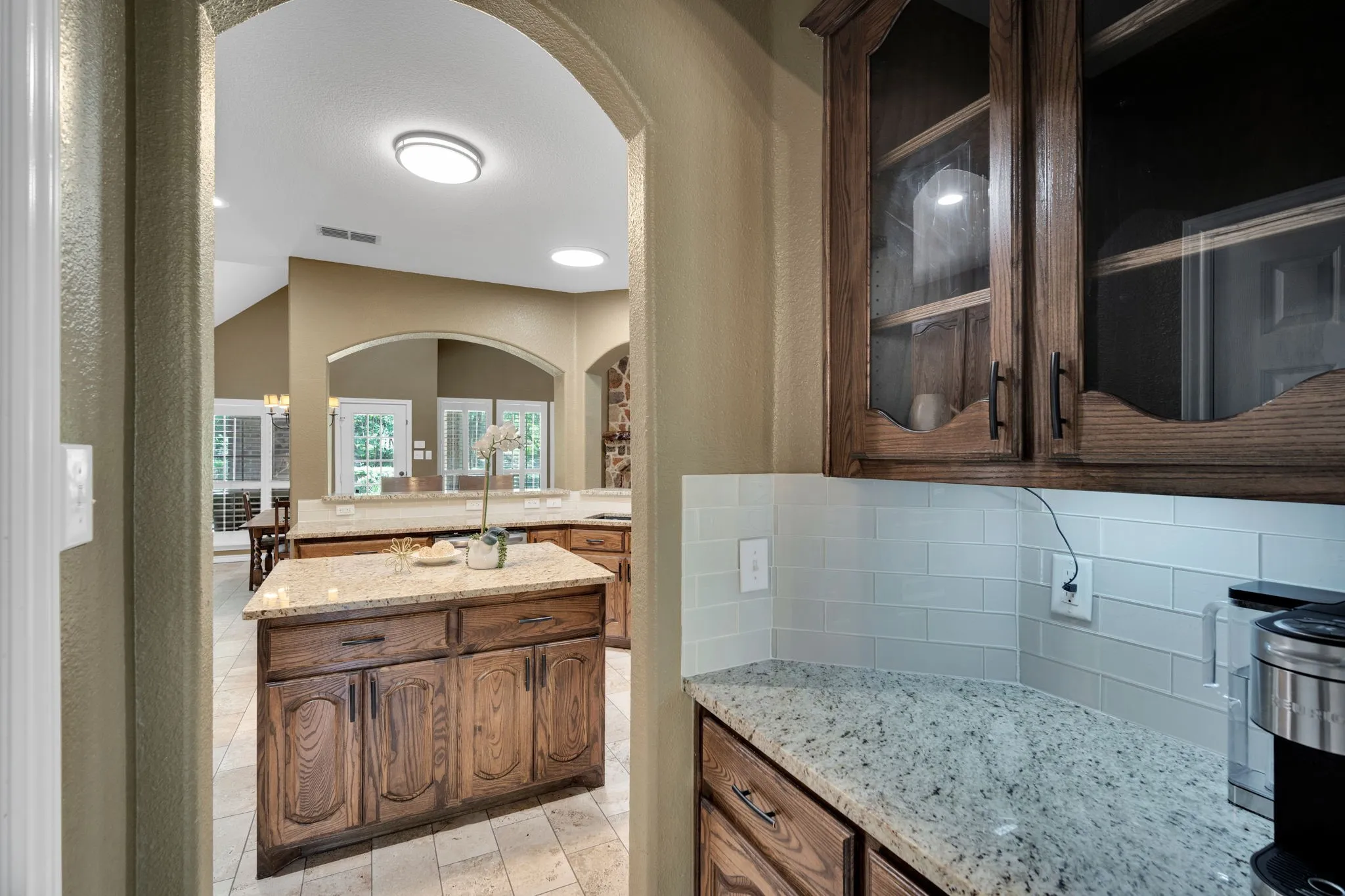 Butler's pantry with elegant glass-front cabinetry, conveniently connecting to the kitchen.