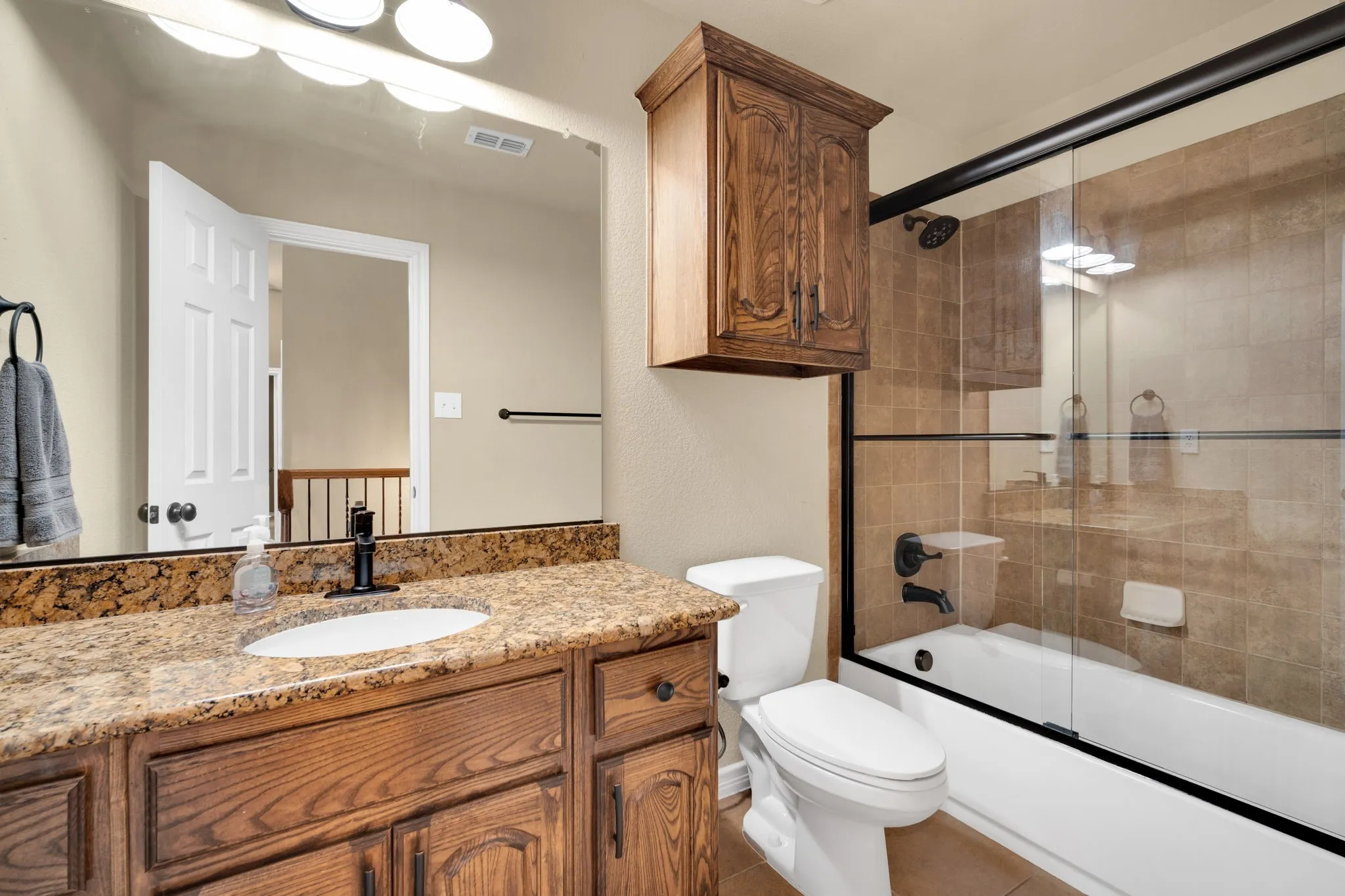 Secondary bathroom with a granite vanity and a tub/shower combo.