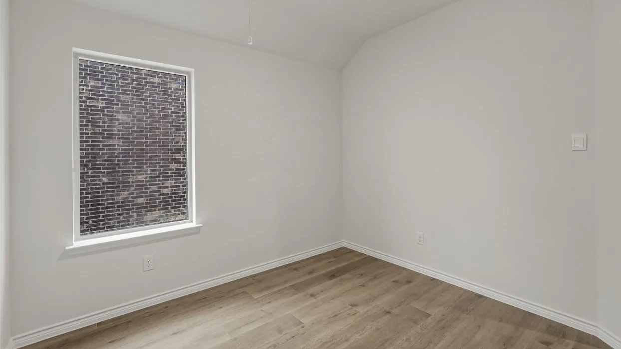 Bright interior space featuring wood-finish flooring, white baseboards, and a window with white trim