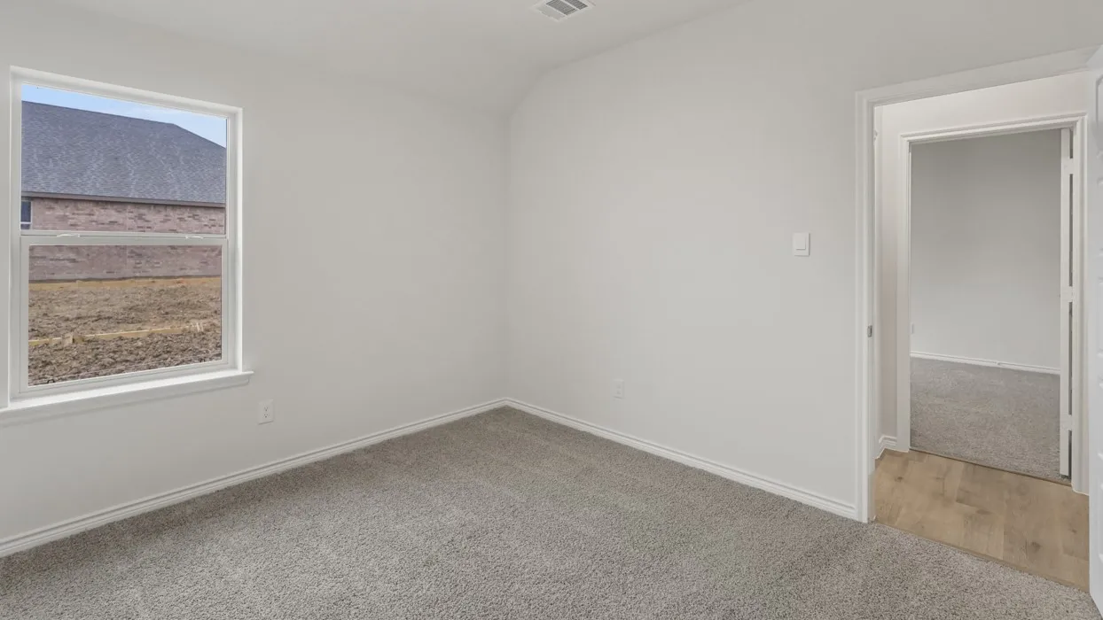 Carpeted room featuring a single window and an open doorway