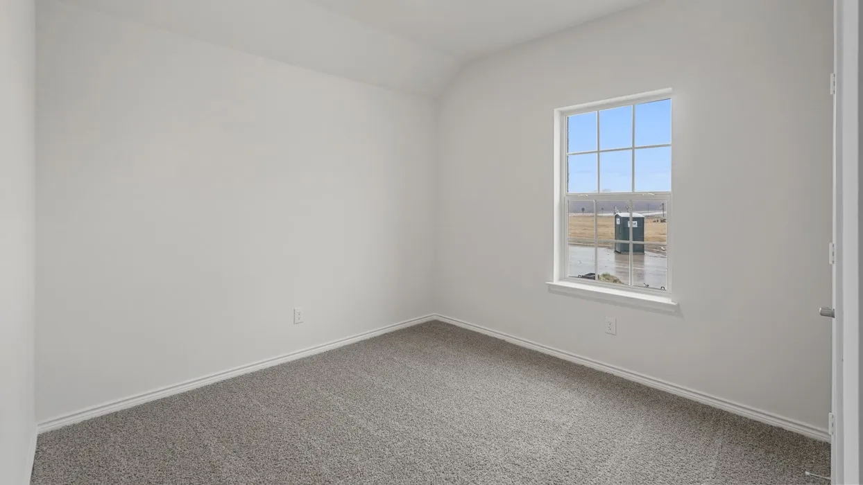 White-painted interior room featuring gray carpeting, a single window with white trim, and a white interior door