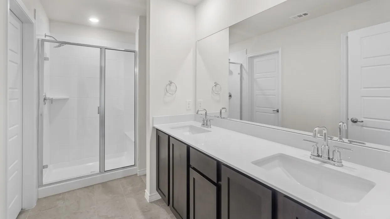 Spacious bathroom featuring a dual vanity with white countertops, undermount sinks, and chrome fixtures