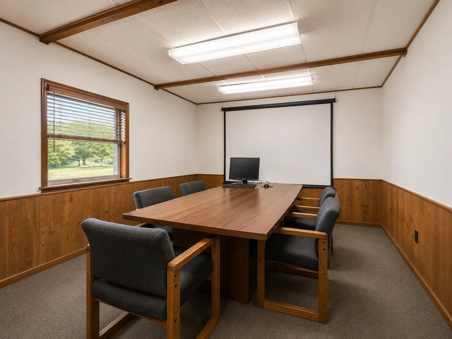 Room featuring wood-finish wainscoting, white walls, and a dropped ceiling with exposed wood-finish beams