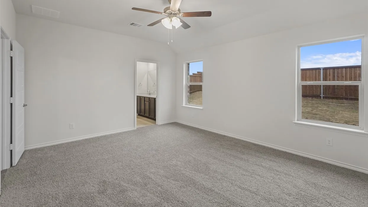 Spacious room featuring vaulted ceilings, light gray carpeting, and white walls
