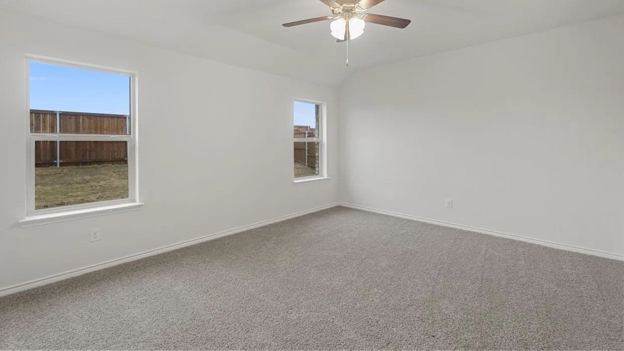 Spacious room featuring vaulted ceilings, light gray carpet flooring, and two double-pane windows
