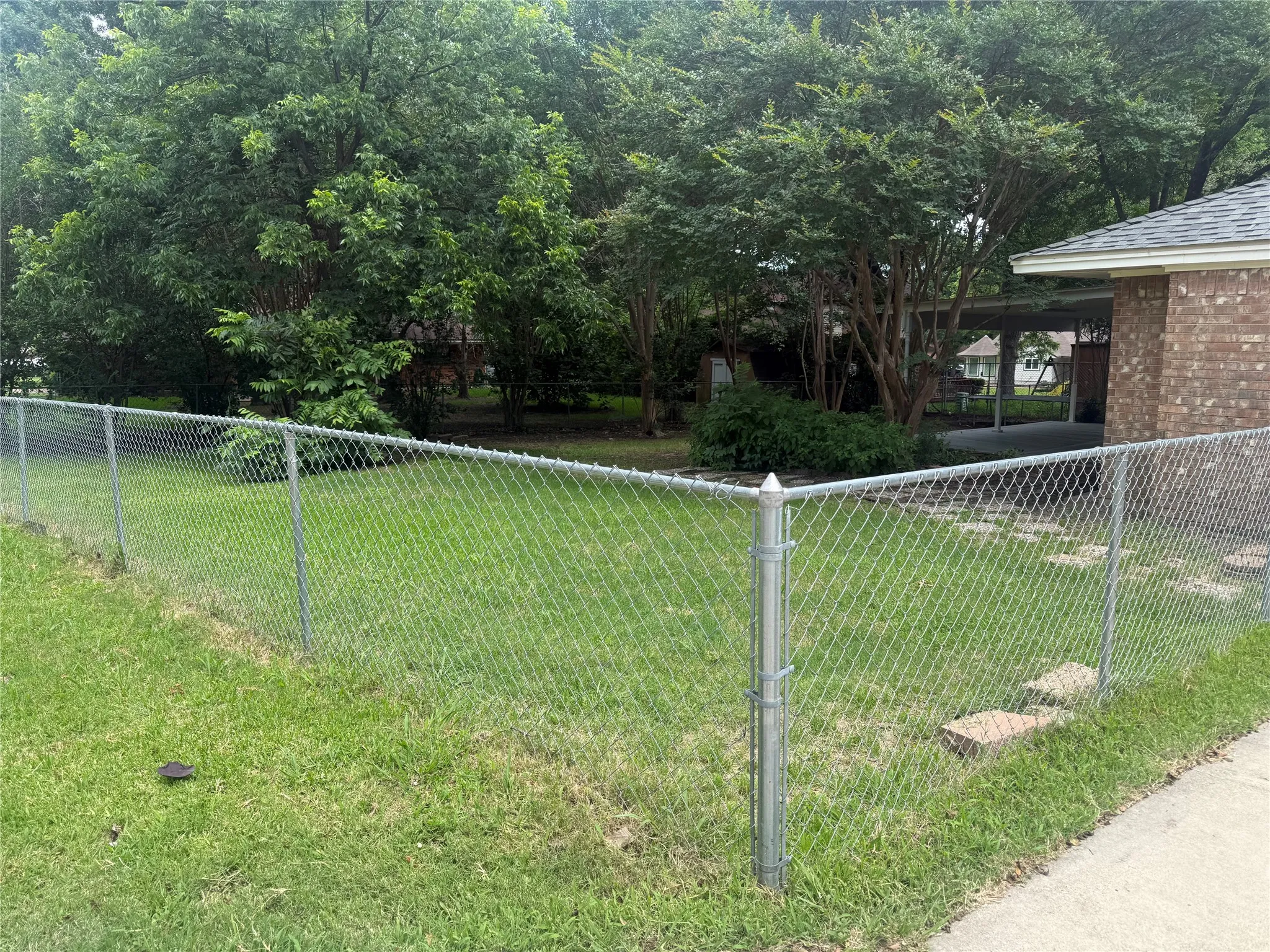 Chain link fence enclosing a green lawn area