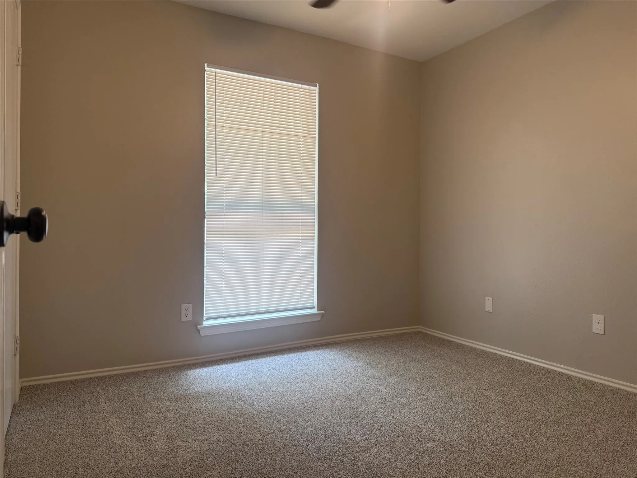 Room featuring neutral paint, carpeted flooring, a window with blinds, and white trim