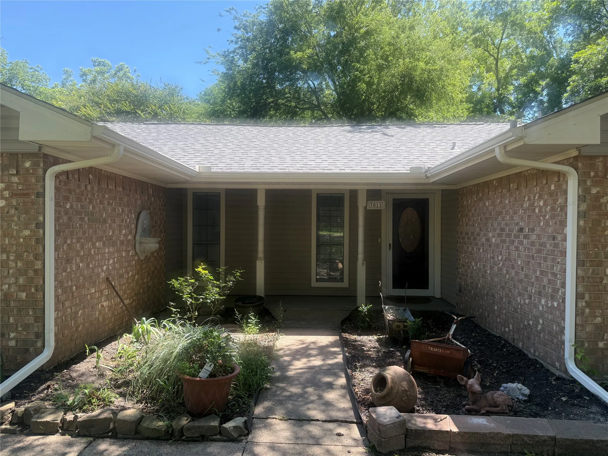 Brick exterior with a gray shingle roof and white gutters