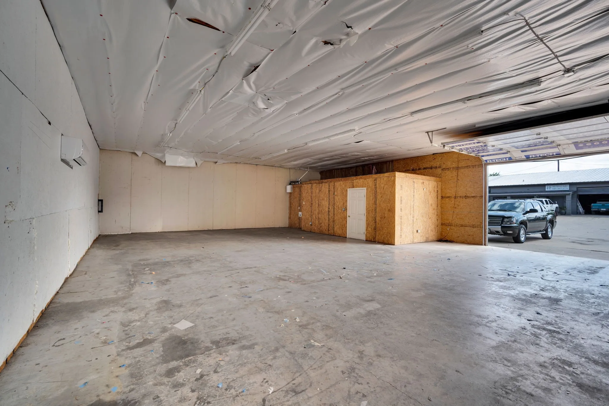 Spacious warehouse bay with soaring ceilings and a built-in office area, offering incredible flexibility for storage, operations, or business use.