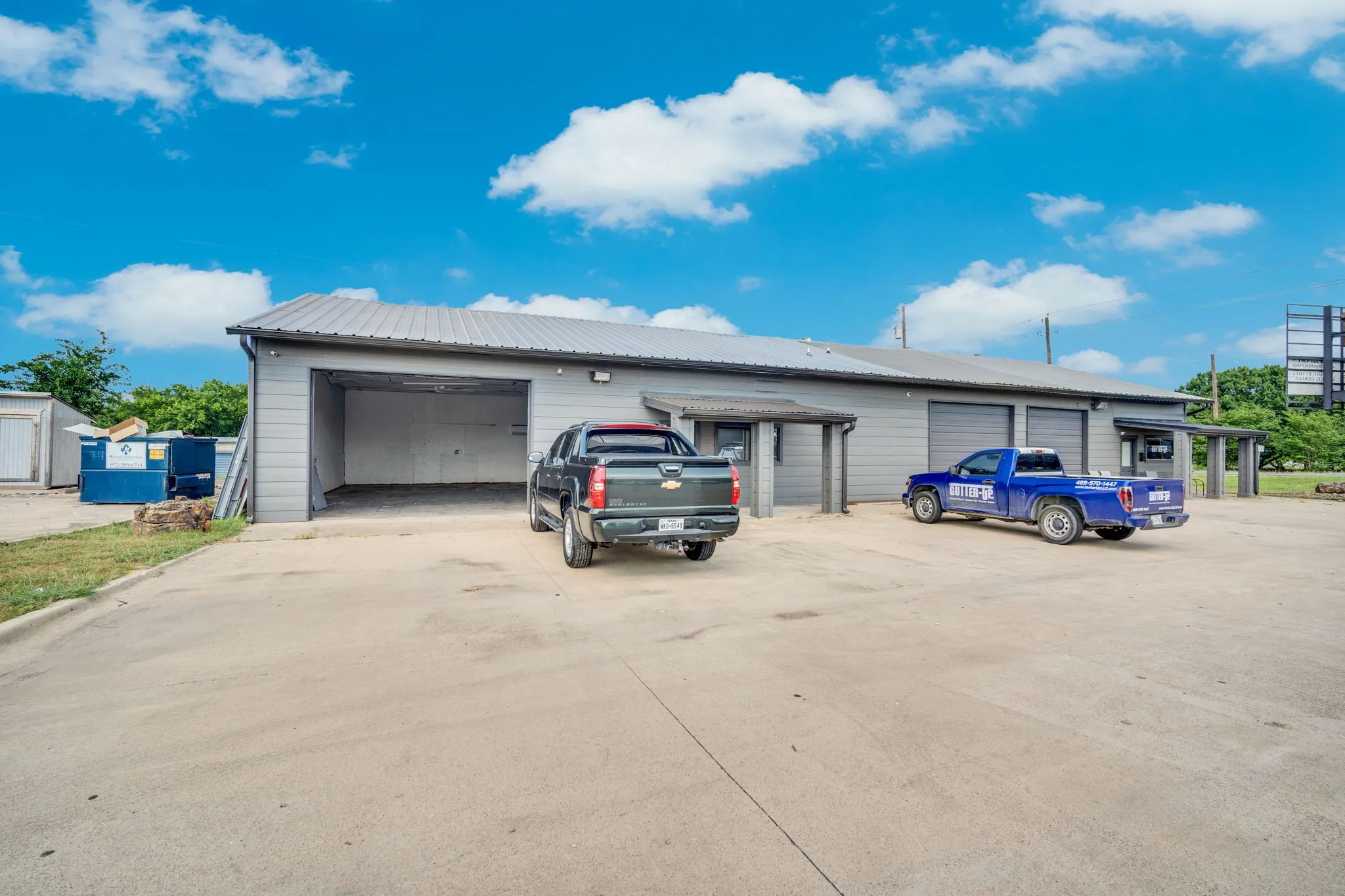 Warehouse exterior featuring several roll-up bay doors and a wide paved lot, built for efficient loading and everyday operations.