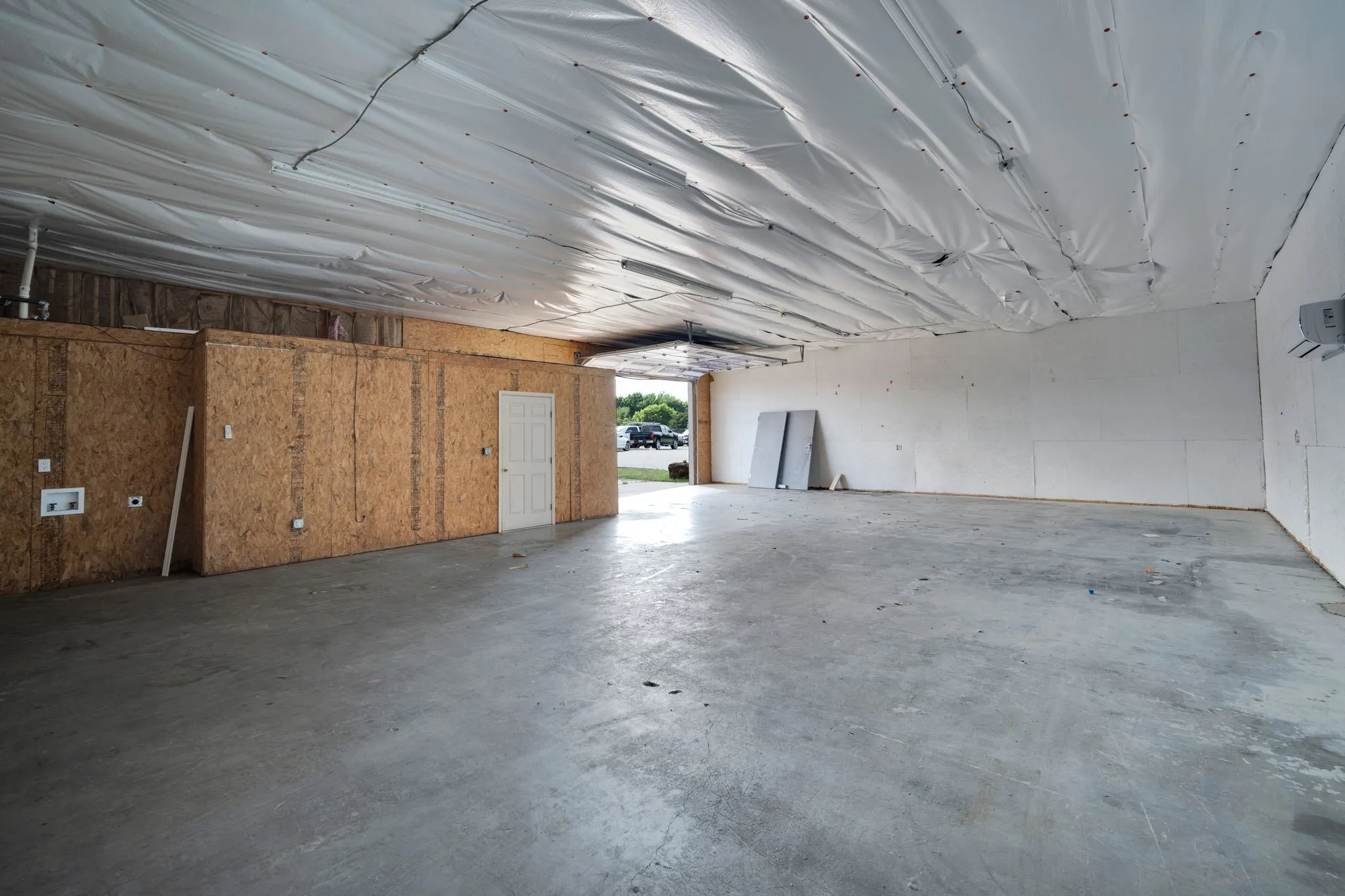 Expansive warehouse interior with a durable concrete floor and open bay access, ideal for equipment, inventory, or fleet storage.