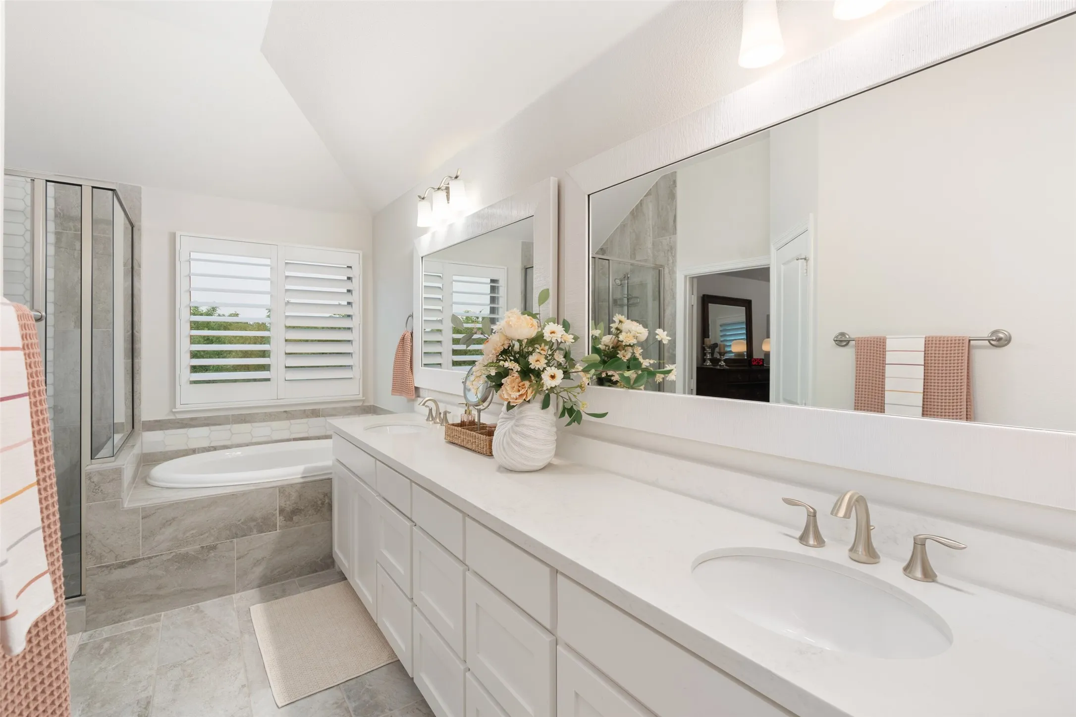 Well appointed primary bathroom with excellent natural lighting; ample counter & storage