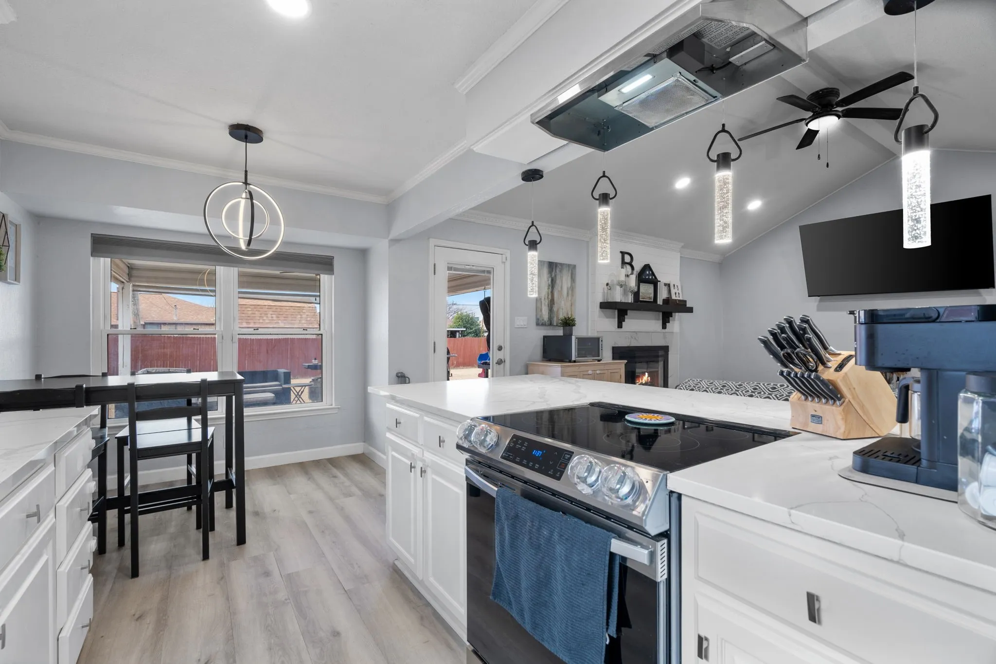 Kitchen featuring white cabinetry, light-toned wood-finish flooring, white countertops, and a modern electric range