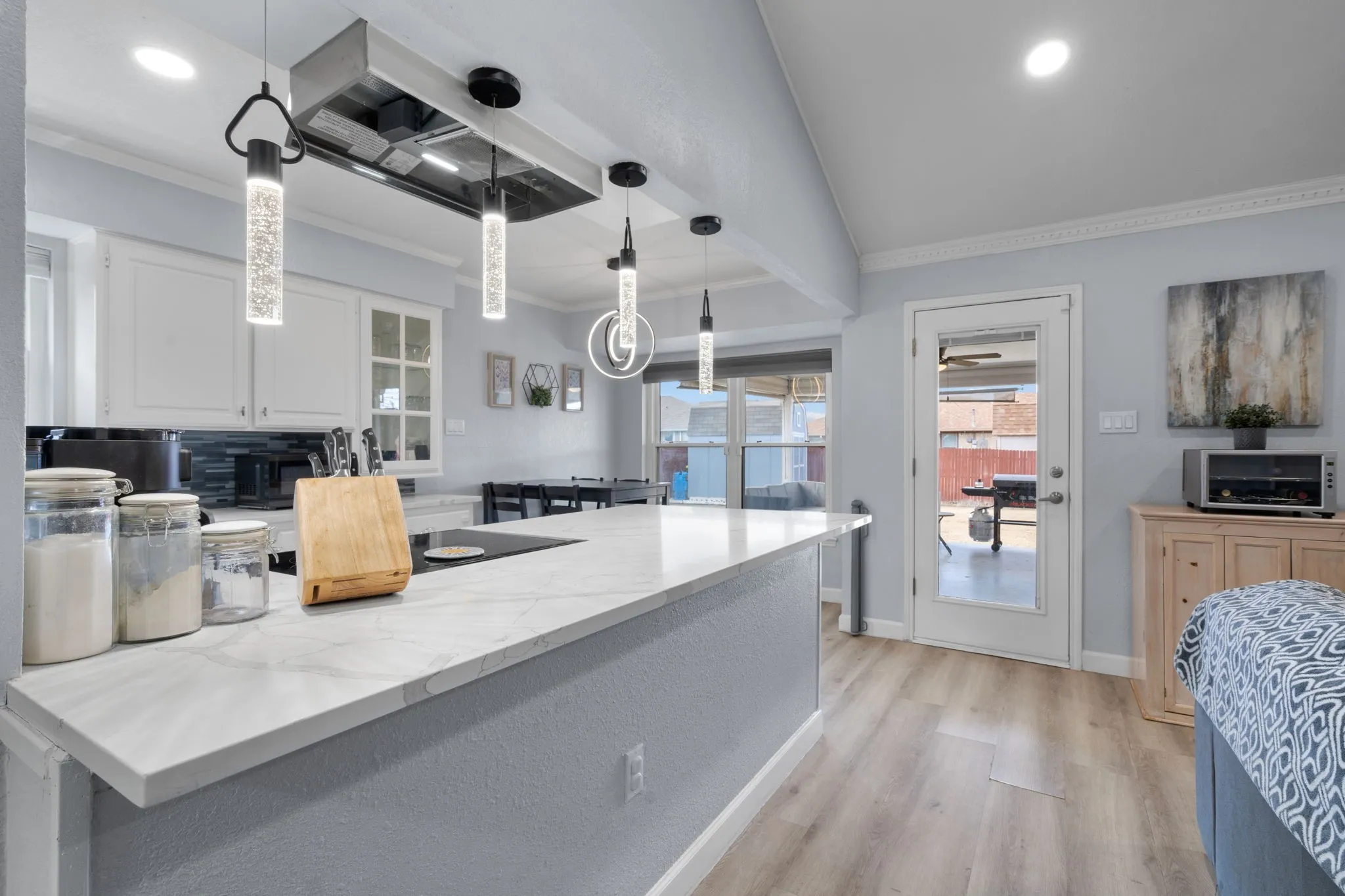 Modern kitchen island featuring a light-toned countertop and built-in cooktop