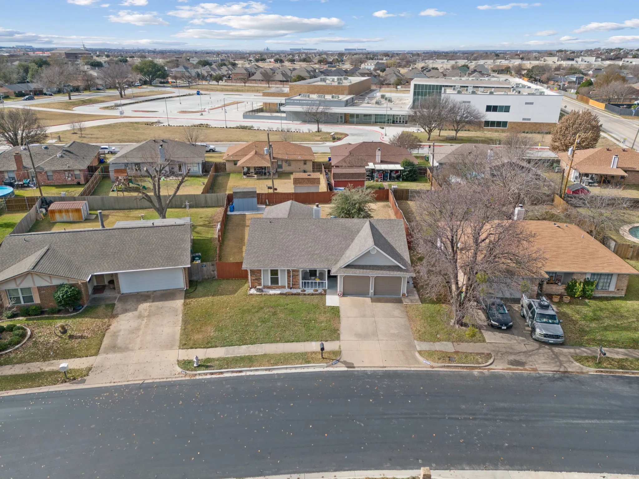 Single-story residence featuring a two-car garage, front yard with green space, and a paved driveway