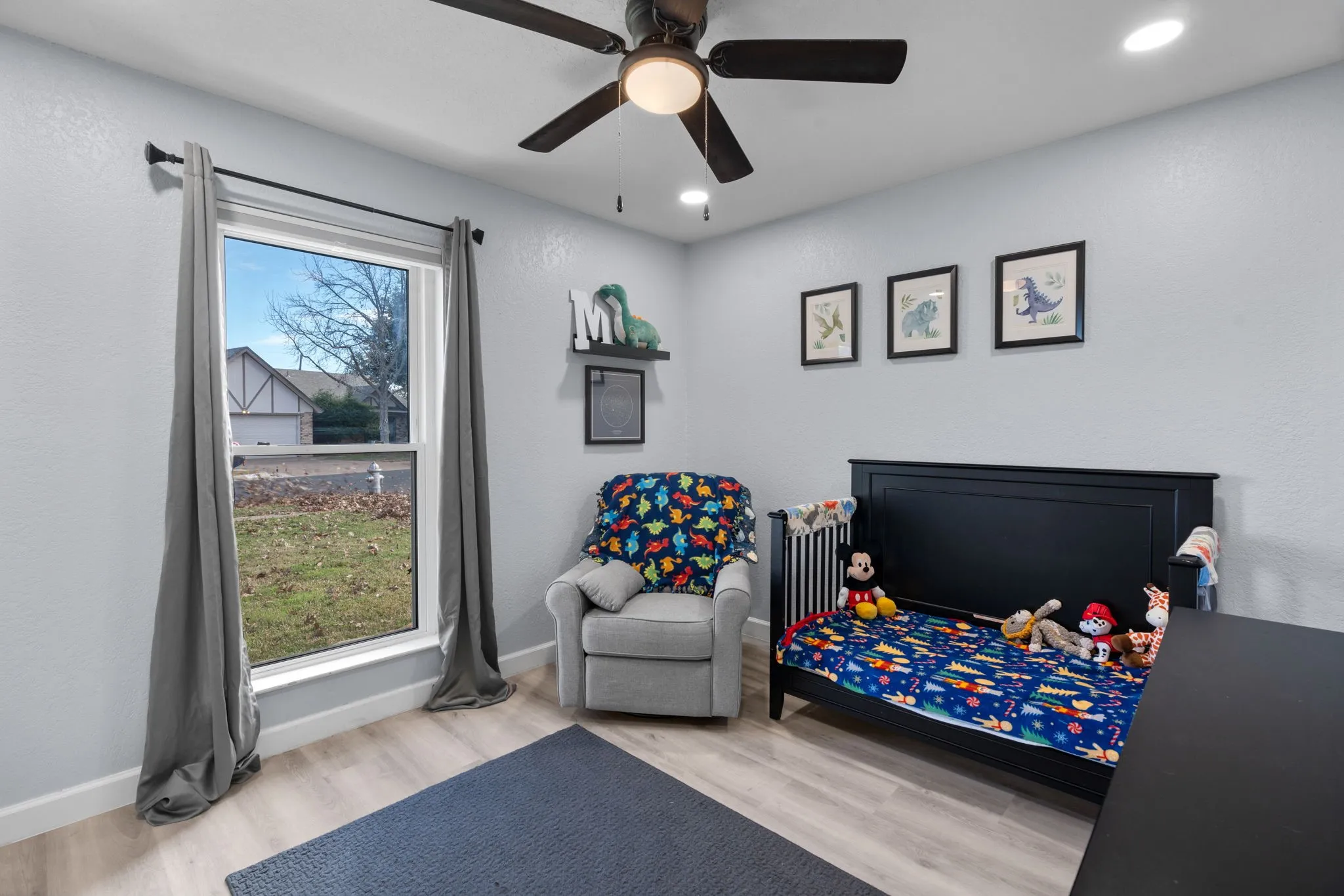 Room with light-toned wood-finish flooring, a ceiling fan with integrated lighting, and recessed ceiling lights