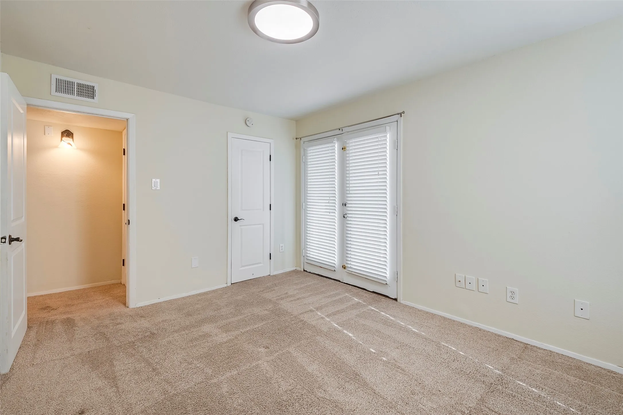 Unfurnished bedroom with light carpet