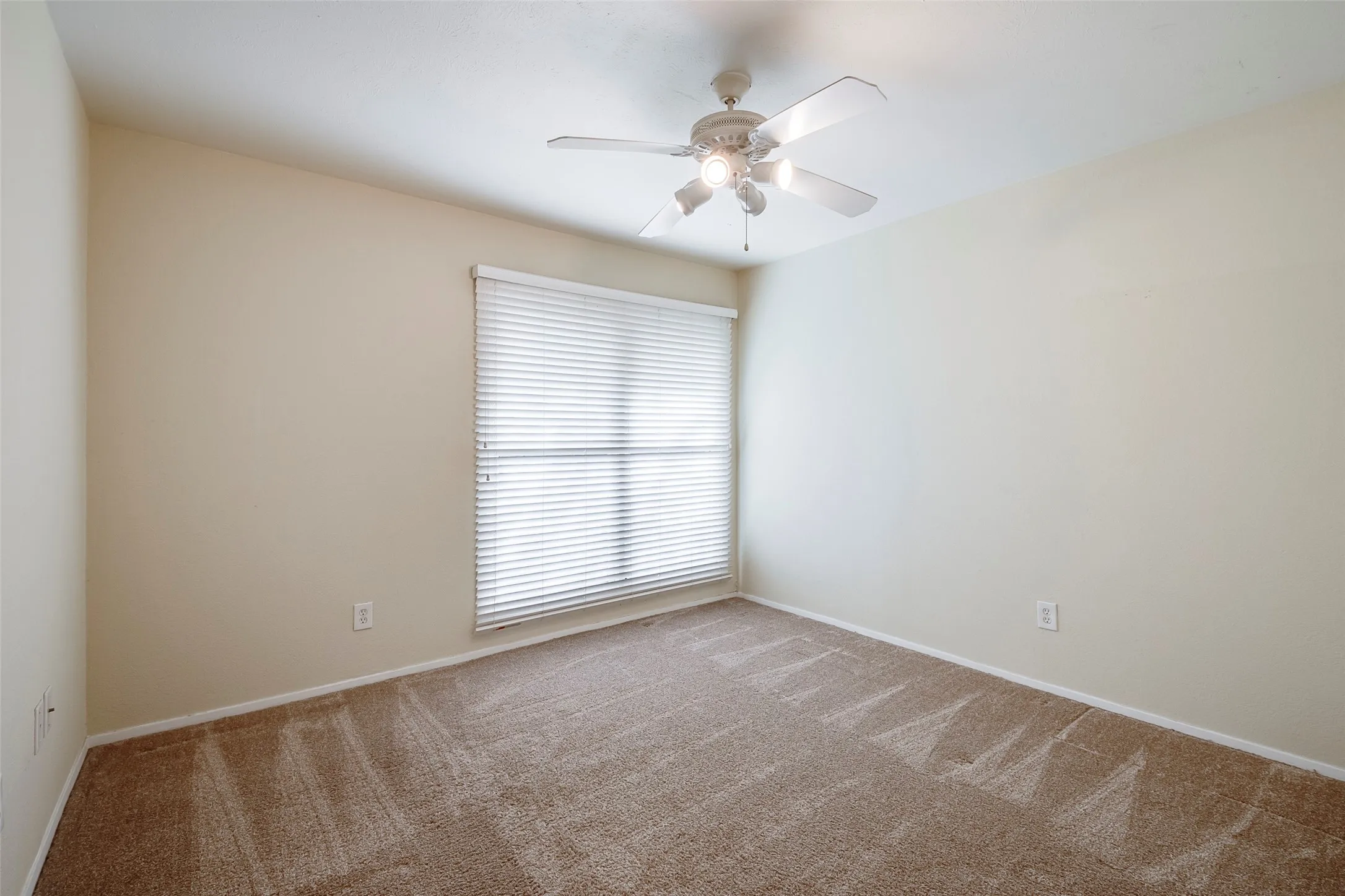 Unfurnished room featuring carpet and ceiling fan