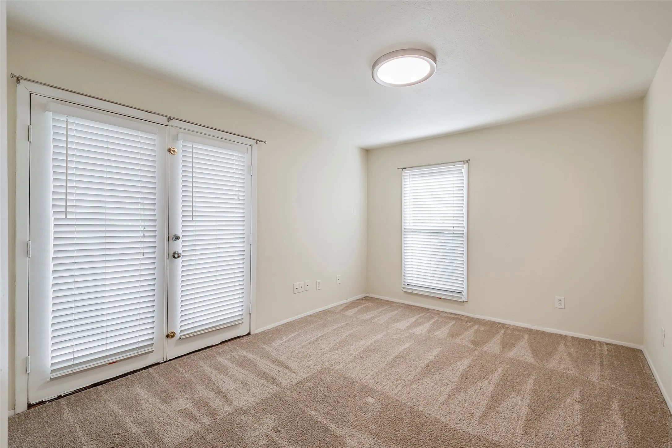 Unfurnished room featuring light carpet