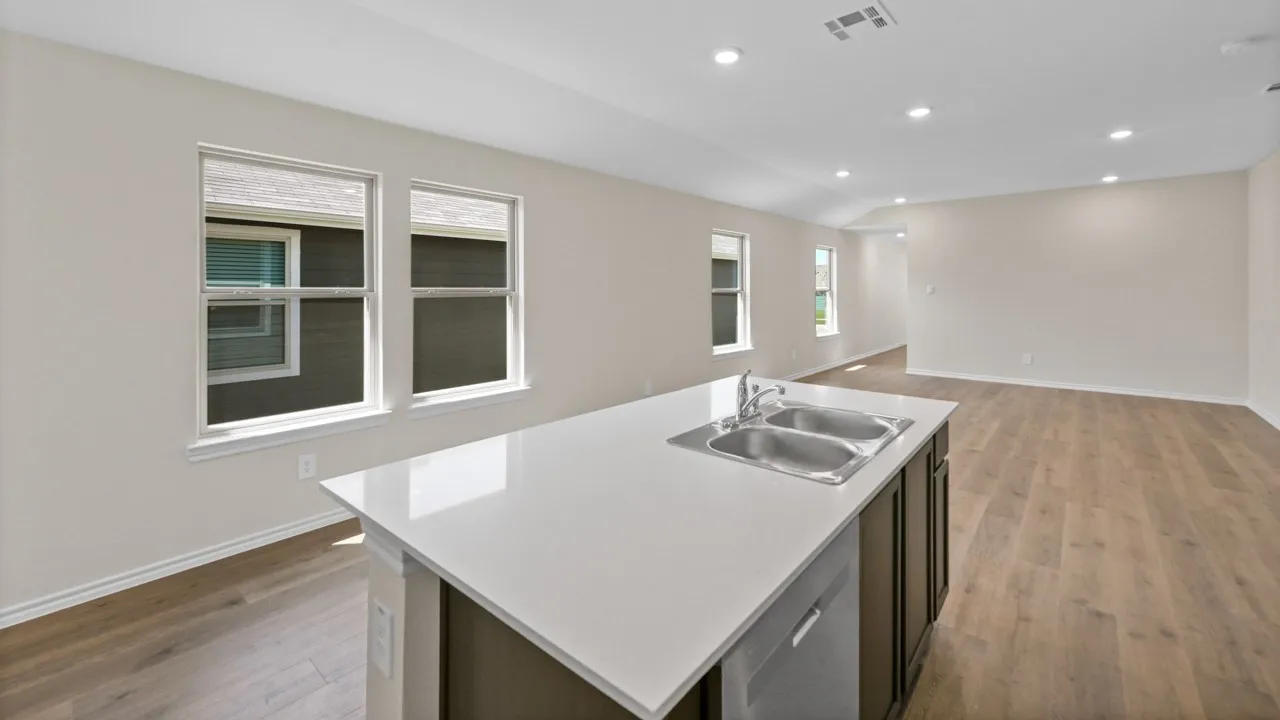 Kitchen island with a double basin stainless steel sink, a pull-down faucet, and a dishwasher