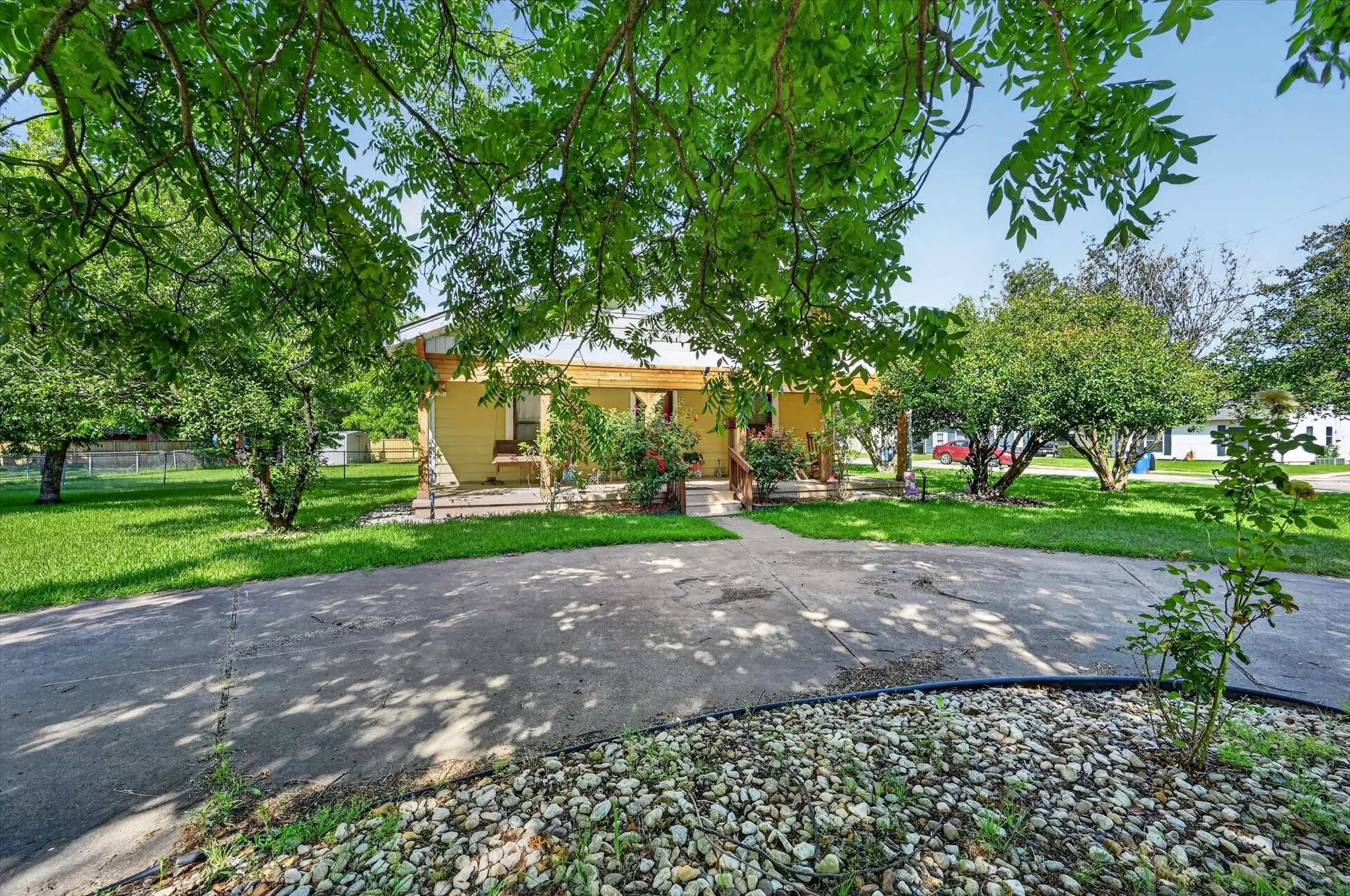 Property exterior with a light yellow facade and a covered front porch featuring wooden posts
