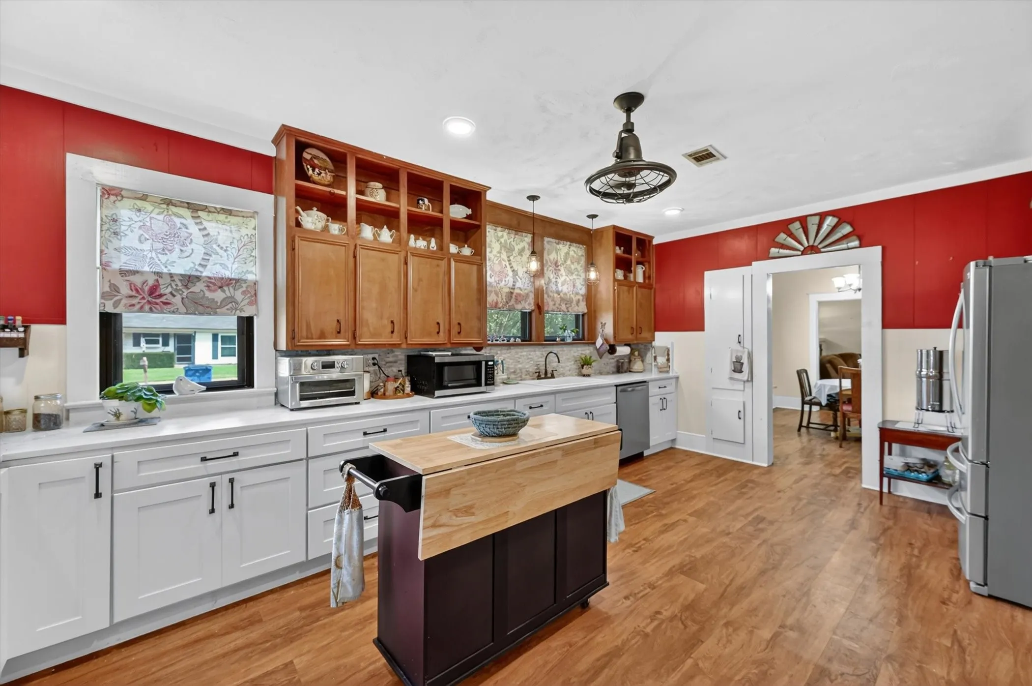 Spacious kitchen featuring wood-finish flooring, white cabinetry, and light-colored countertops