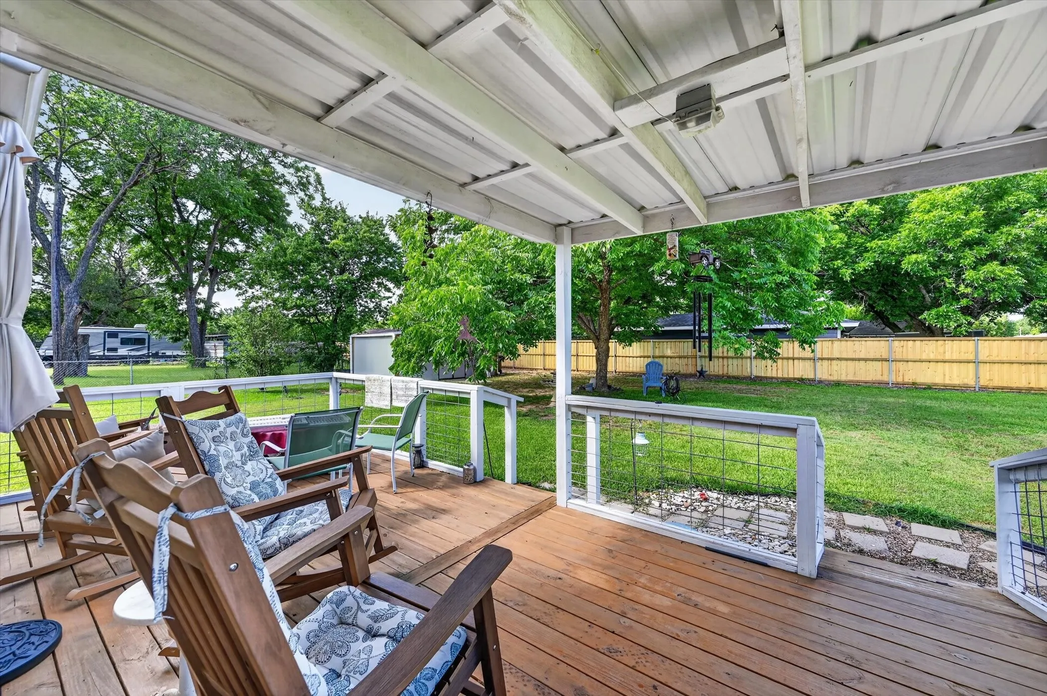 Expansive covered deck featuring wood-finish decking and a white metal roof