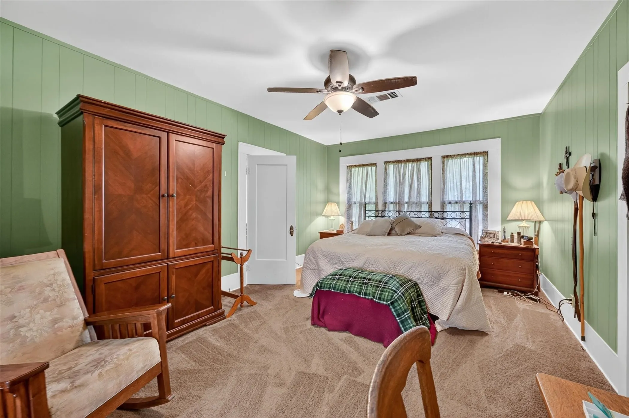 Carpeted room featuring vertical wood paneling and white trim
