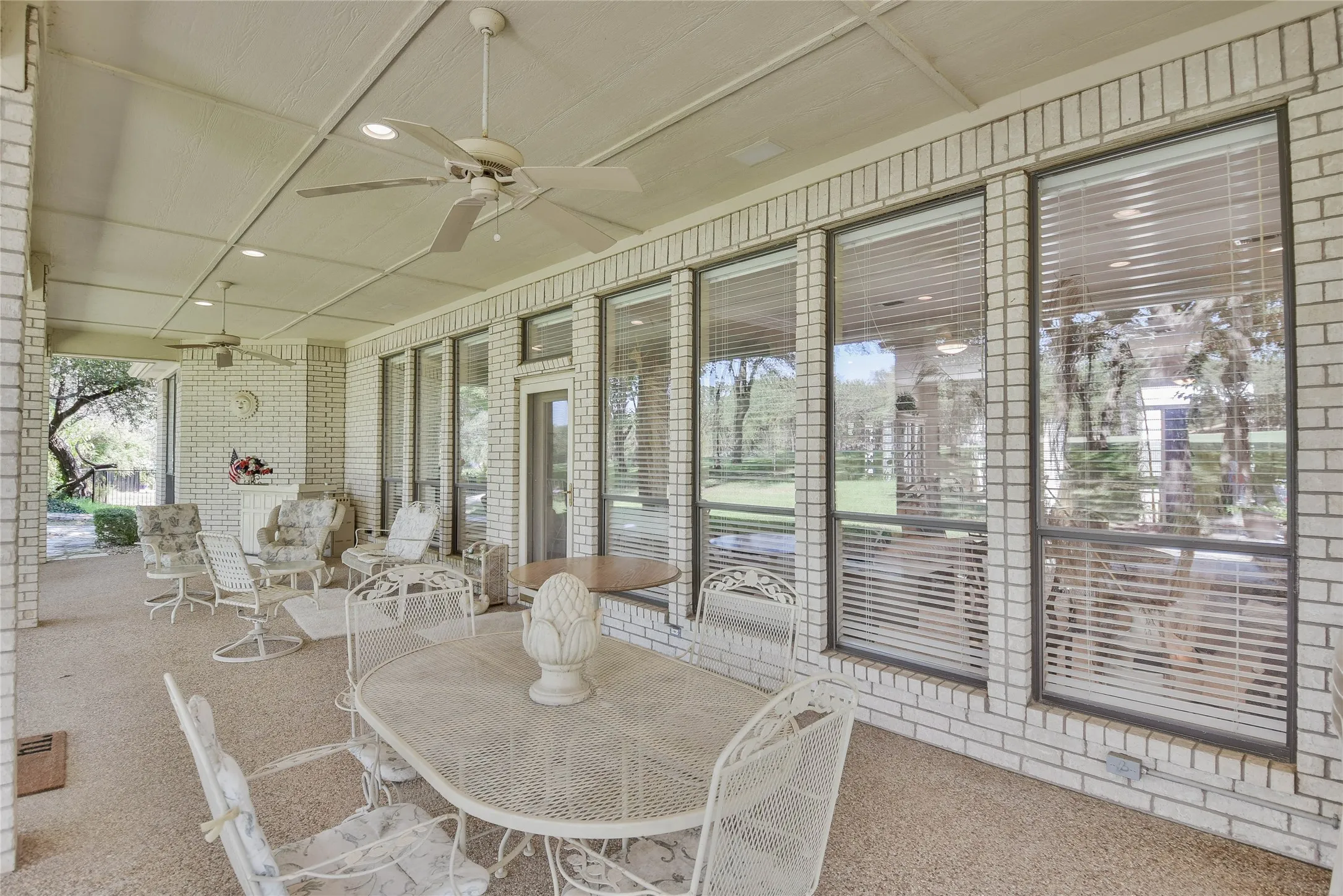 Sunroom / solarium featuring ceiling fan and a patio