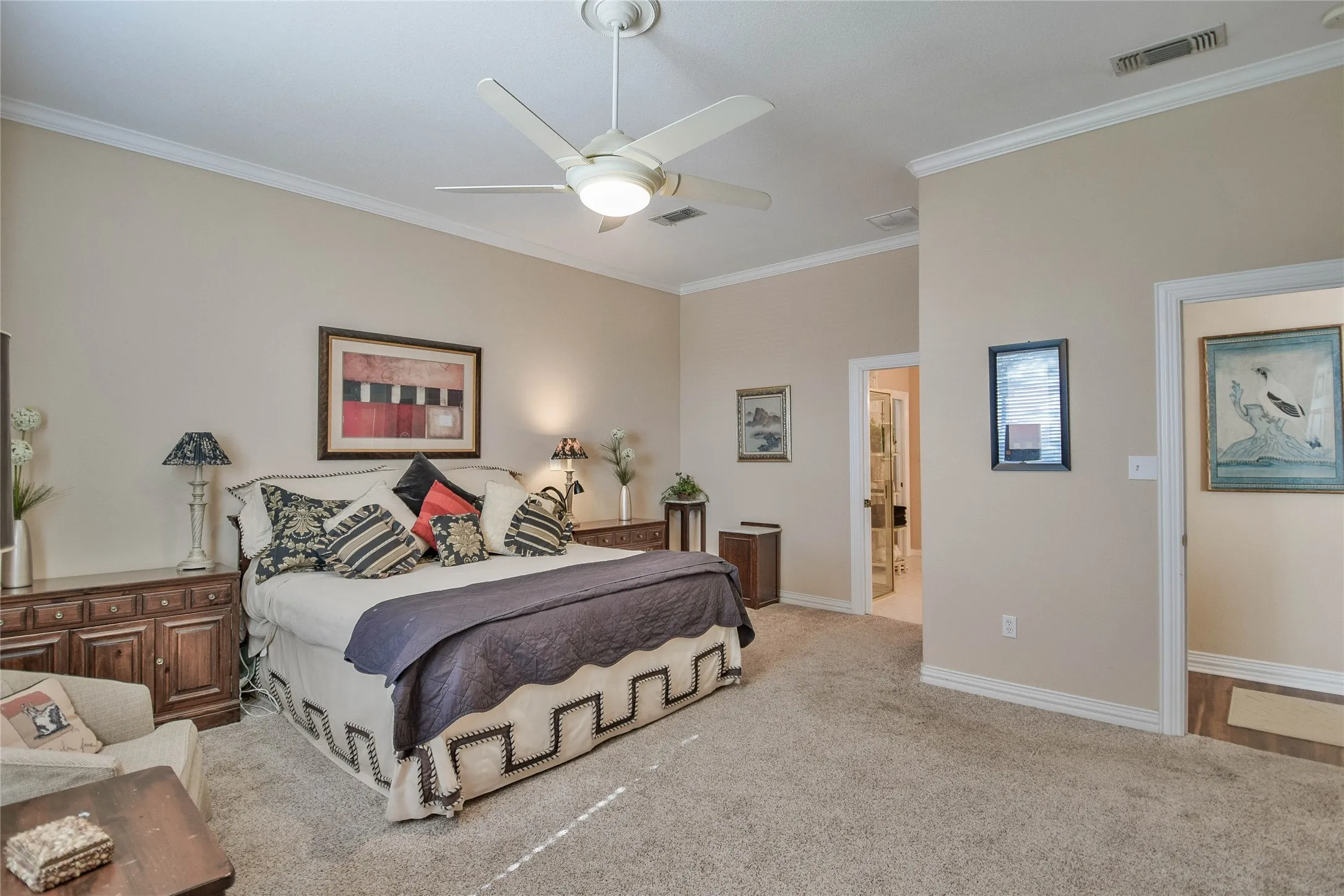 Carpeted bedroom featuring crown molding and a ceiling fan